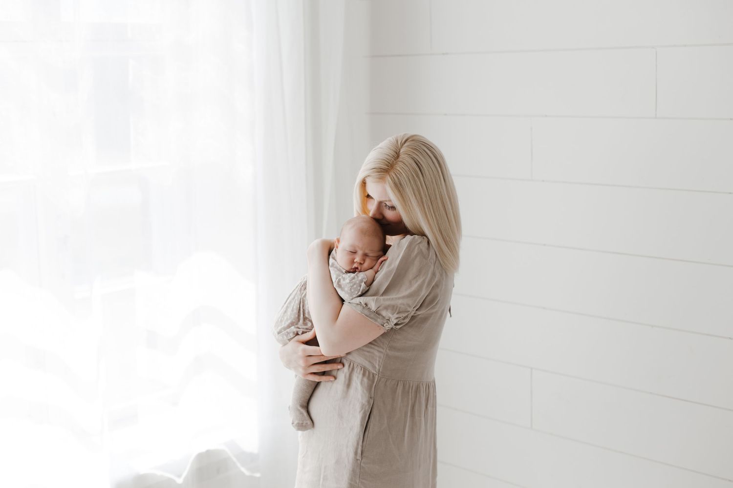 Light and airy family portraits showing intimate moments between parents and infant.