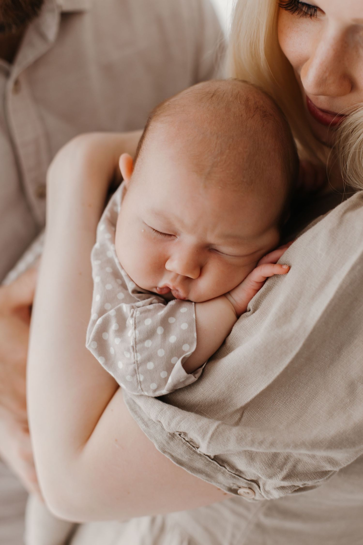 Series of close-up shots showing peaceful sleeping baby nestled against soft beige fabric.