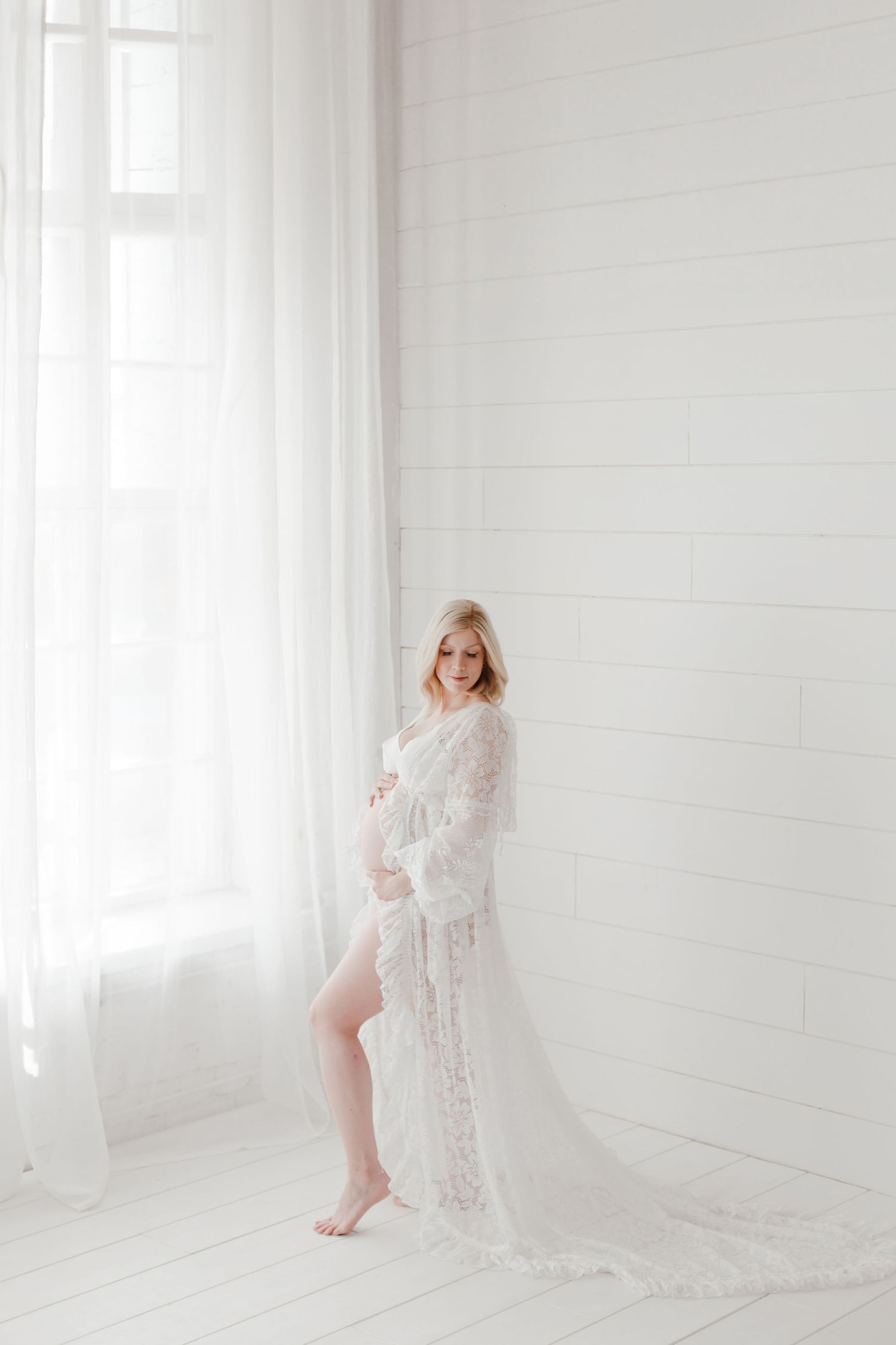 Ethereal boudoir photography featuring delicate white lace in a bright sunlit room.