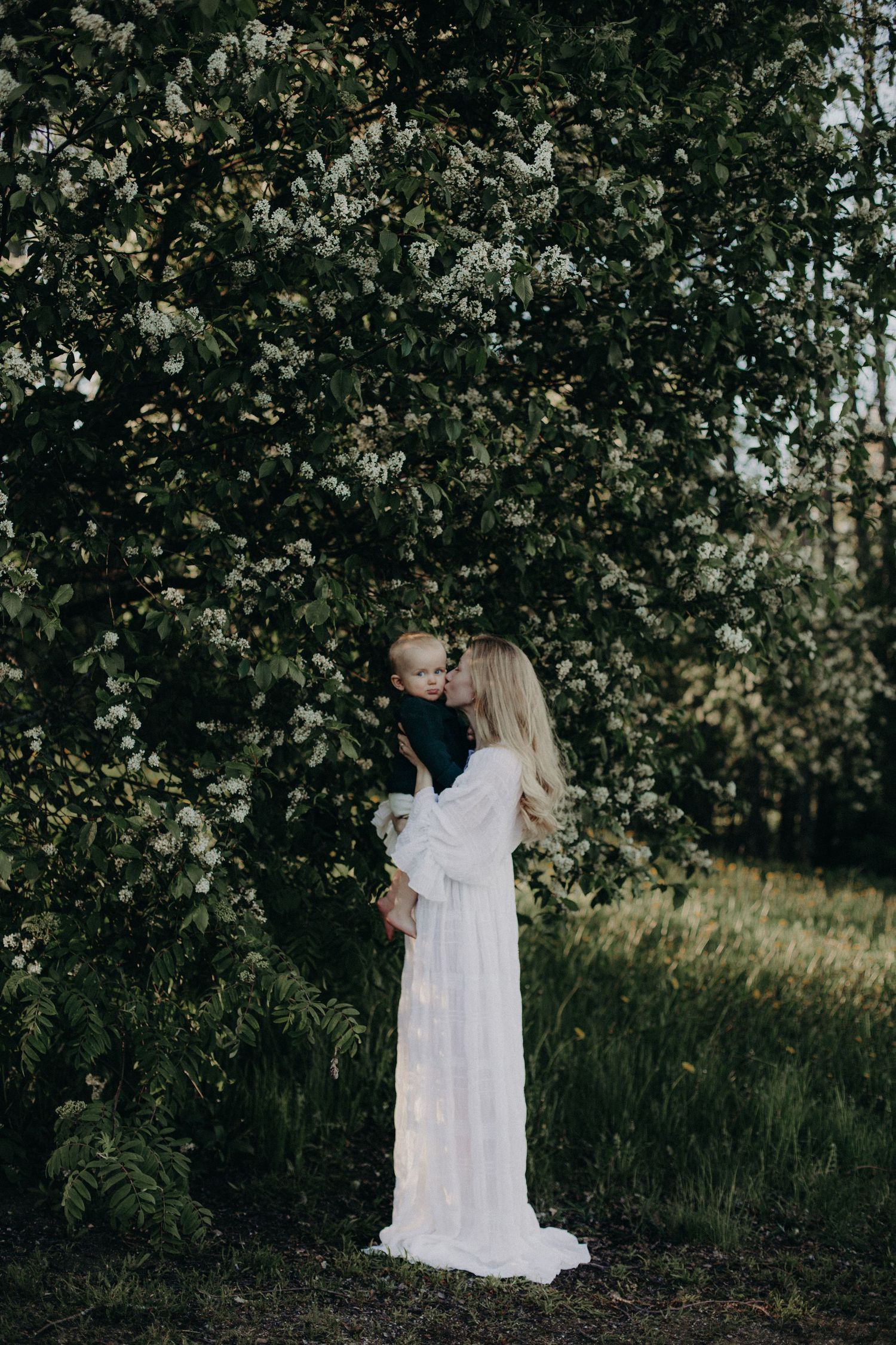A flowing white dress creates ethereal movement against a natural garden setting.