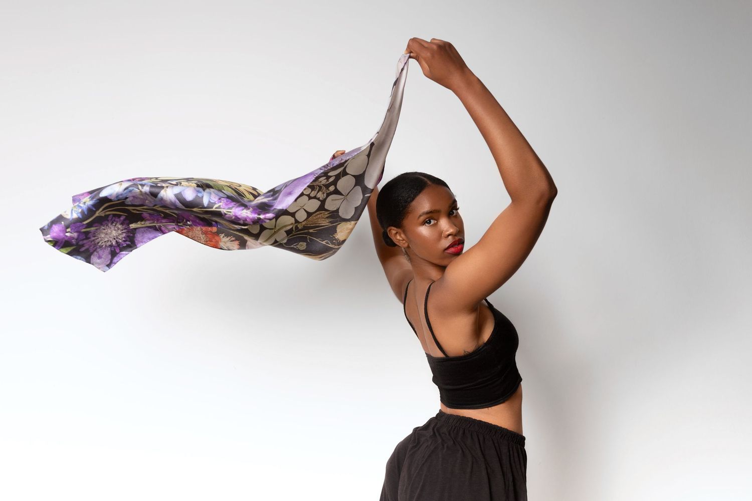Dynamic movement shots with flowing purple and floral fabric in studio setting.