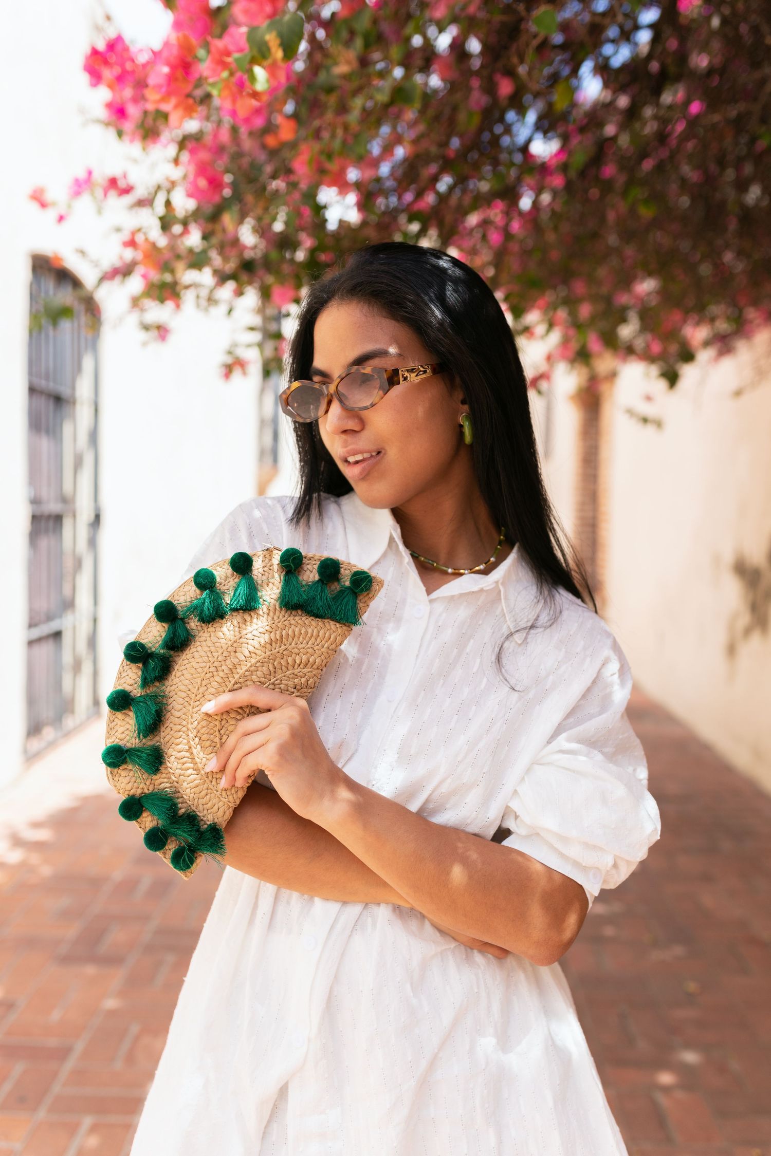 Summer fashion shoot with decorative fan and pink flowering trees.