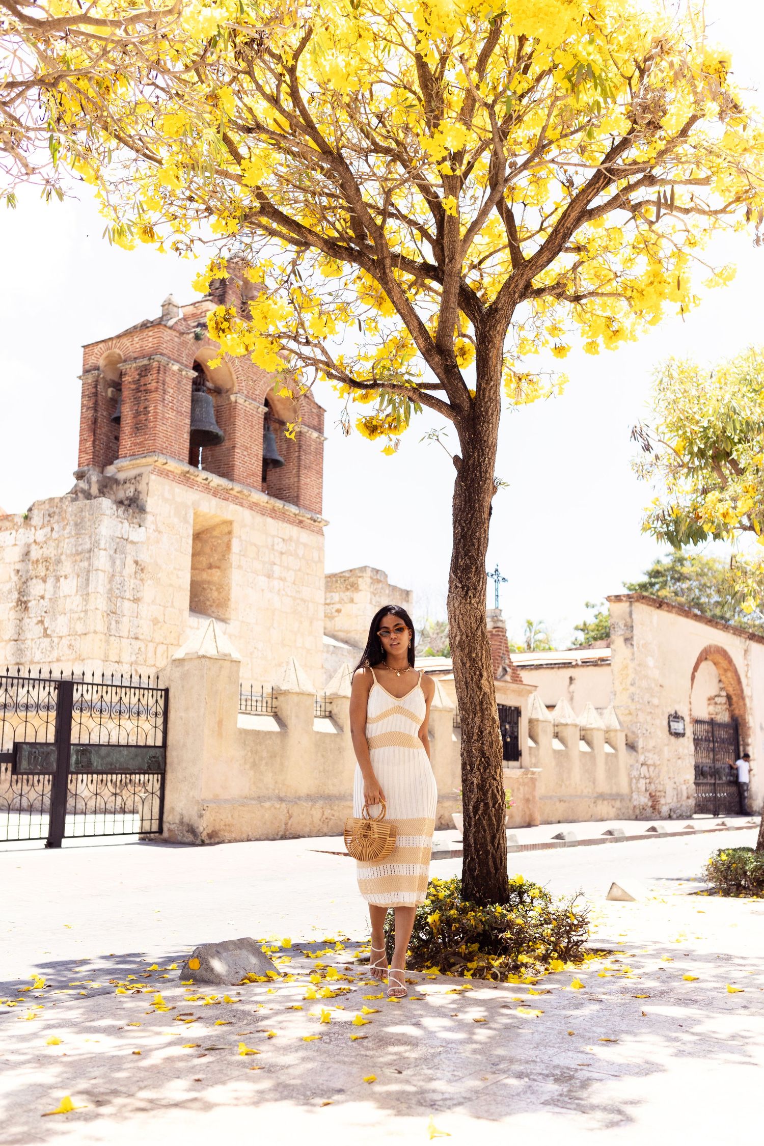 Outdoor photography session with yellow autumn trees and stone architecture.