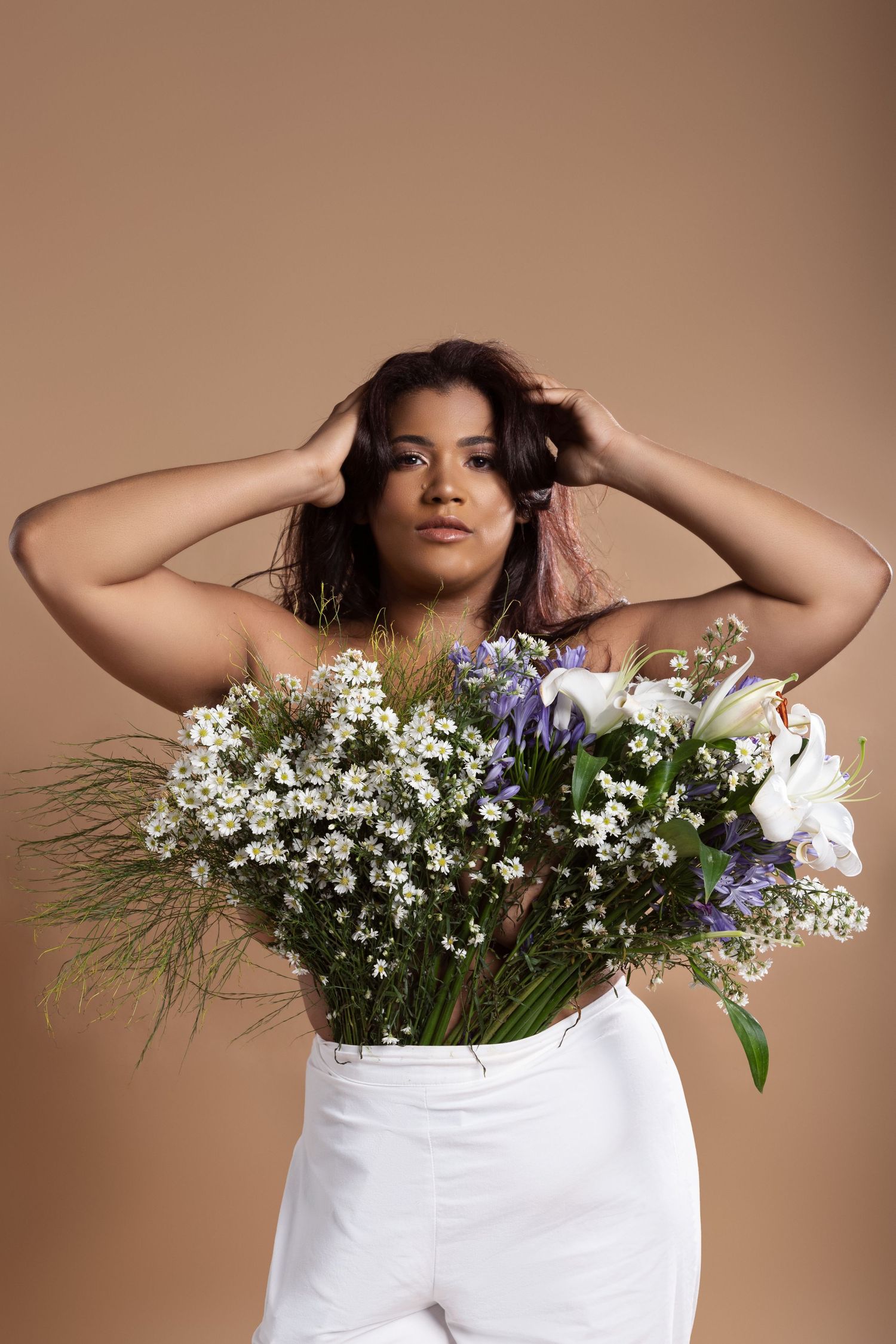 Artistic portrait series featuring white floral arrangements against a warm brown backdrop.