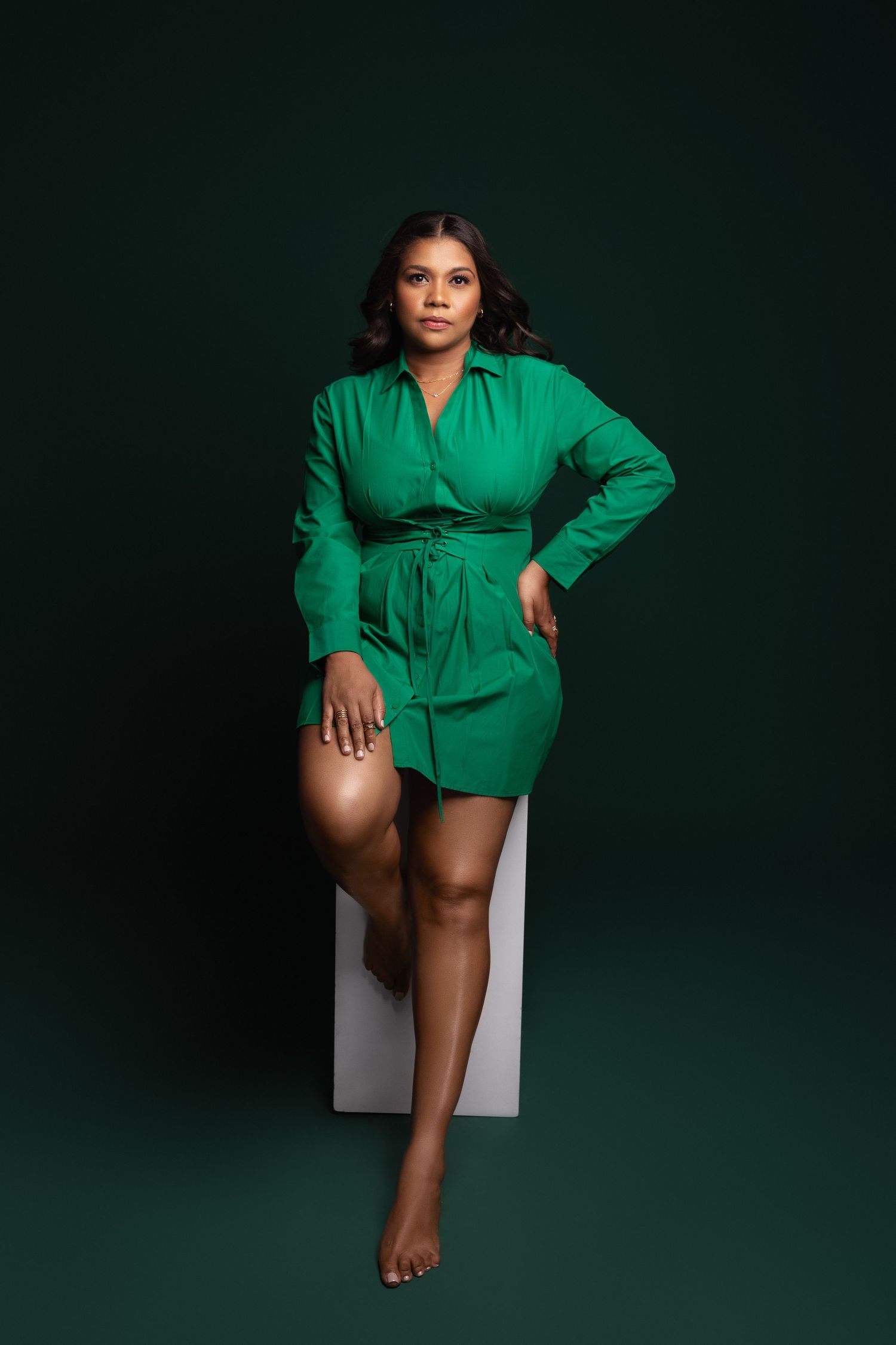 Fashion series in emerald green shirt dress with minimalist white props.