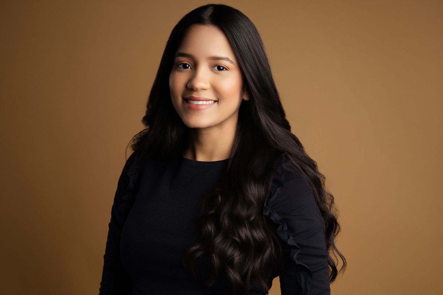 Professional headshots against warm brown background in studio lighting.