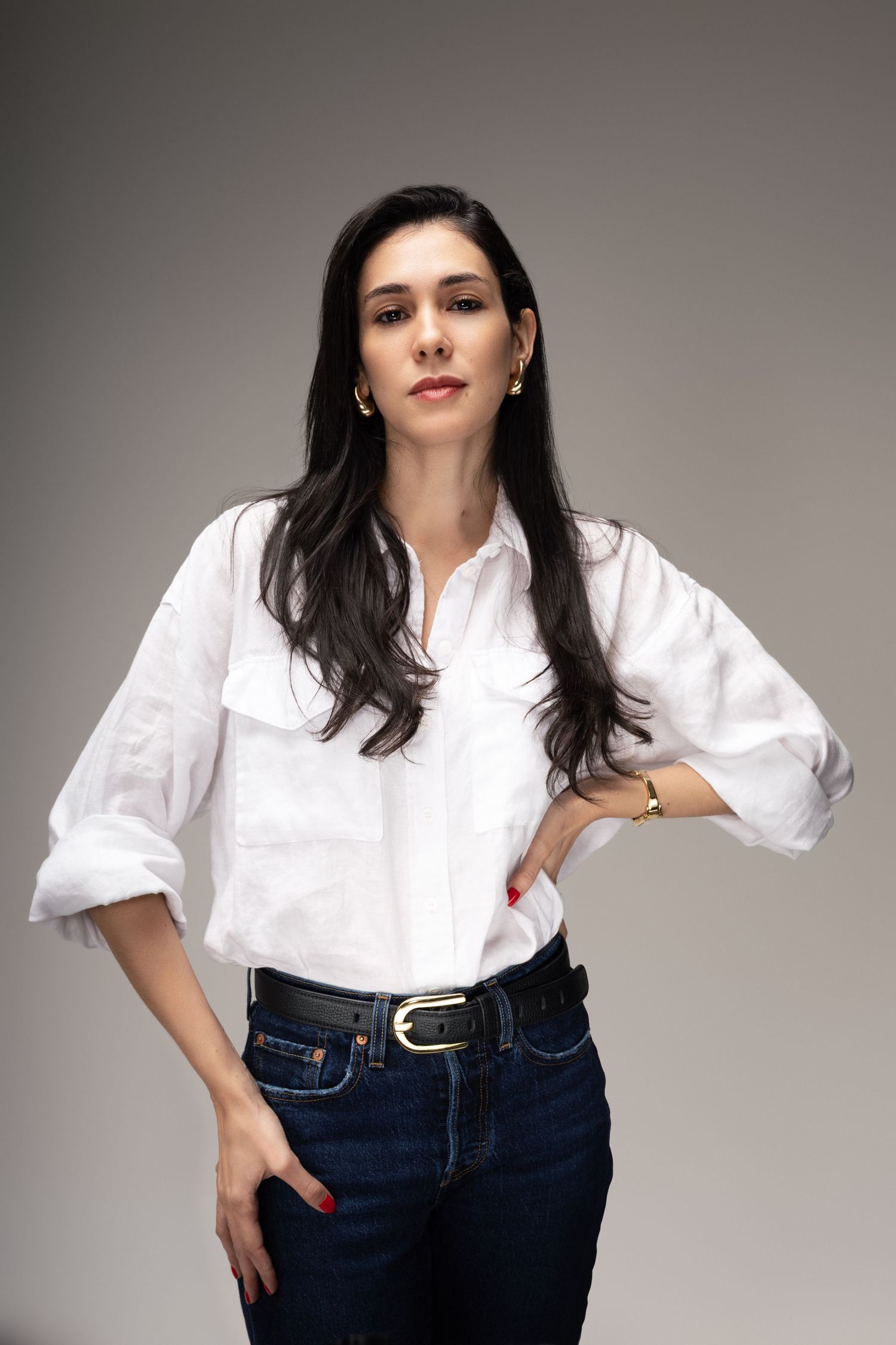 Classic white button-down shirt paired with dark denim in studio setting.
