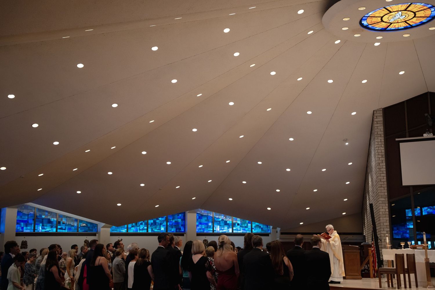 Wedding church with spotlit ceiling and gathered guests.