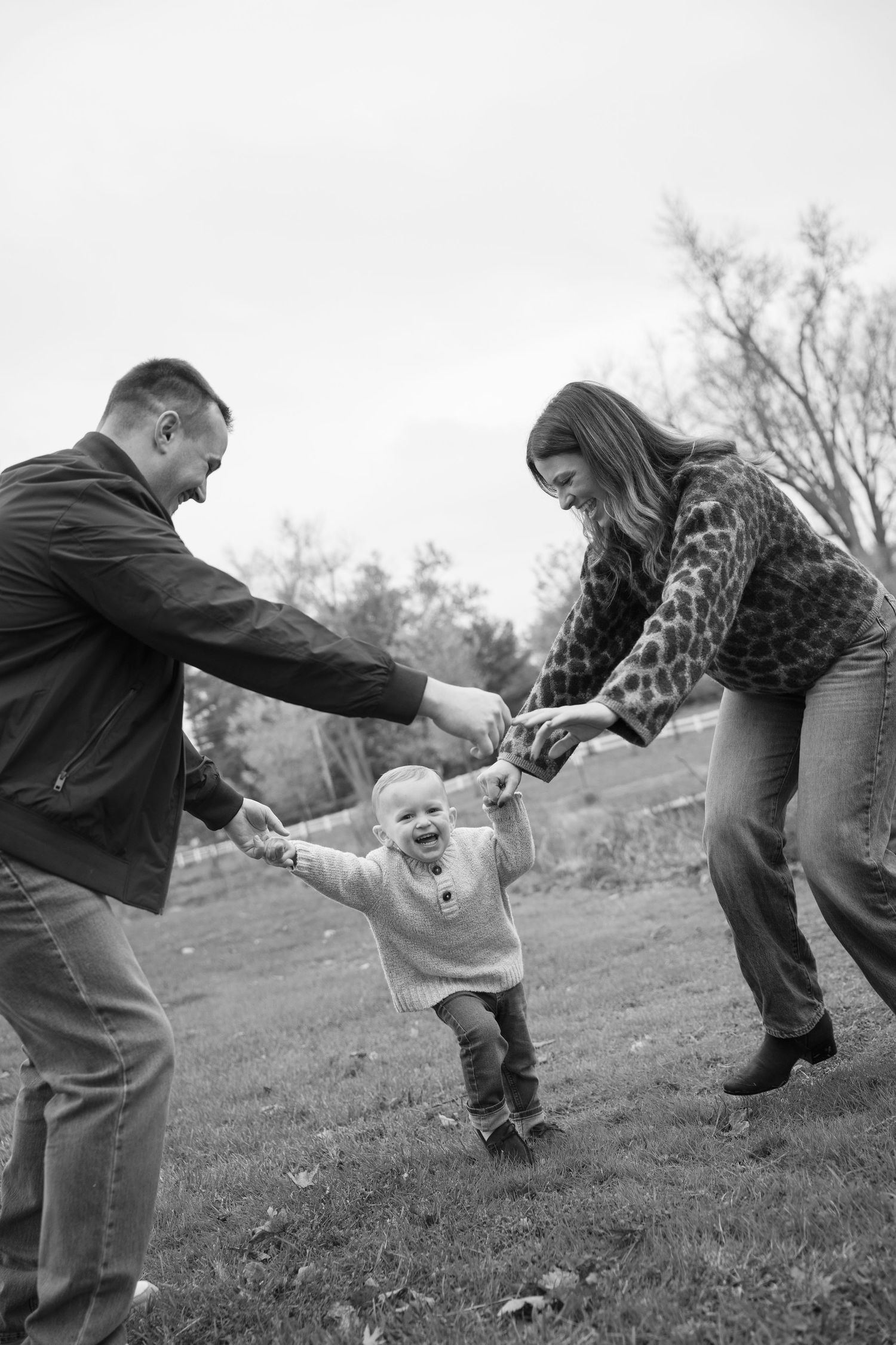 Black and white sequence of playful family moments outdoors showing joyful interaction and movement during a family session.