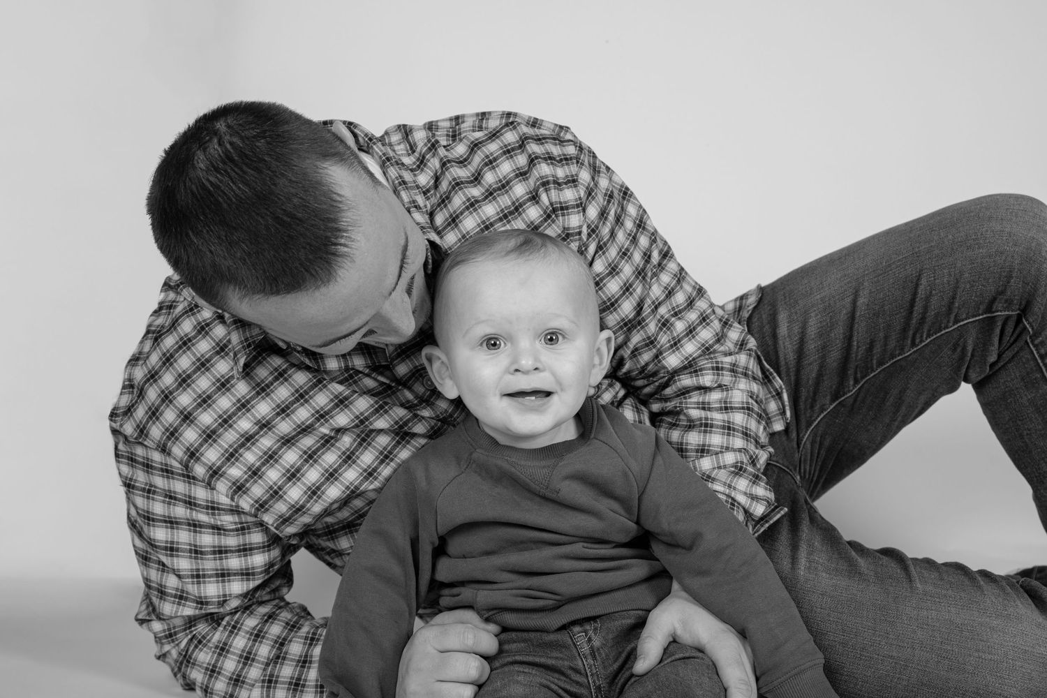Black and white family portrait studio session with dad and baby