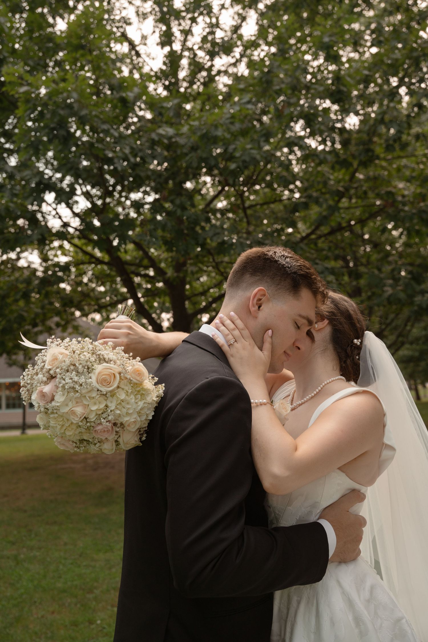 A romantic wedding kiss sequence captured in a garden setting with delicate floral bouquet details.