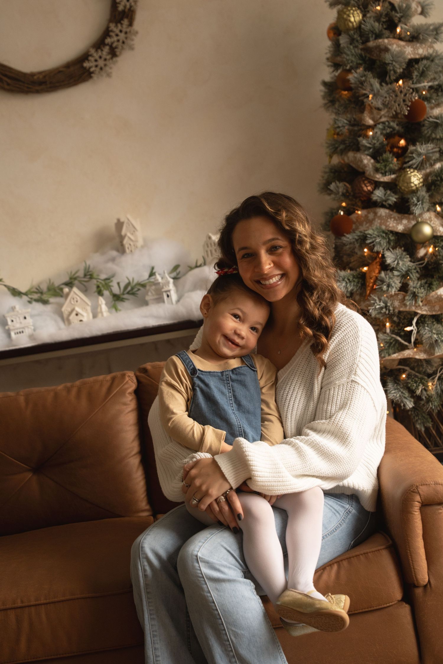 A heartwarming family moment is captured on a couch during the holiday season in a studio.