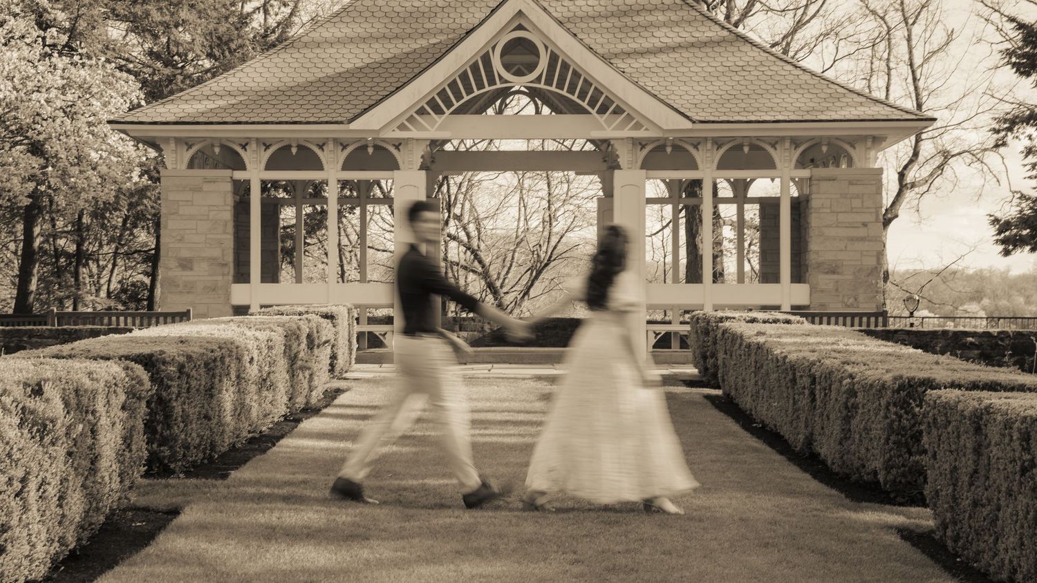 Panoramic view of elegant classical architecture with couple walking in foreground.