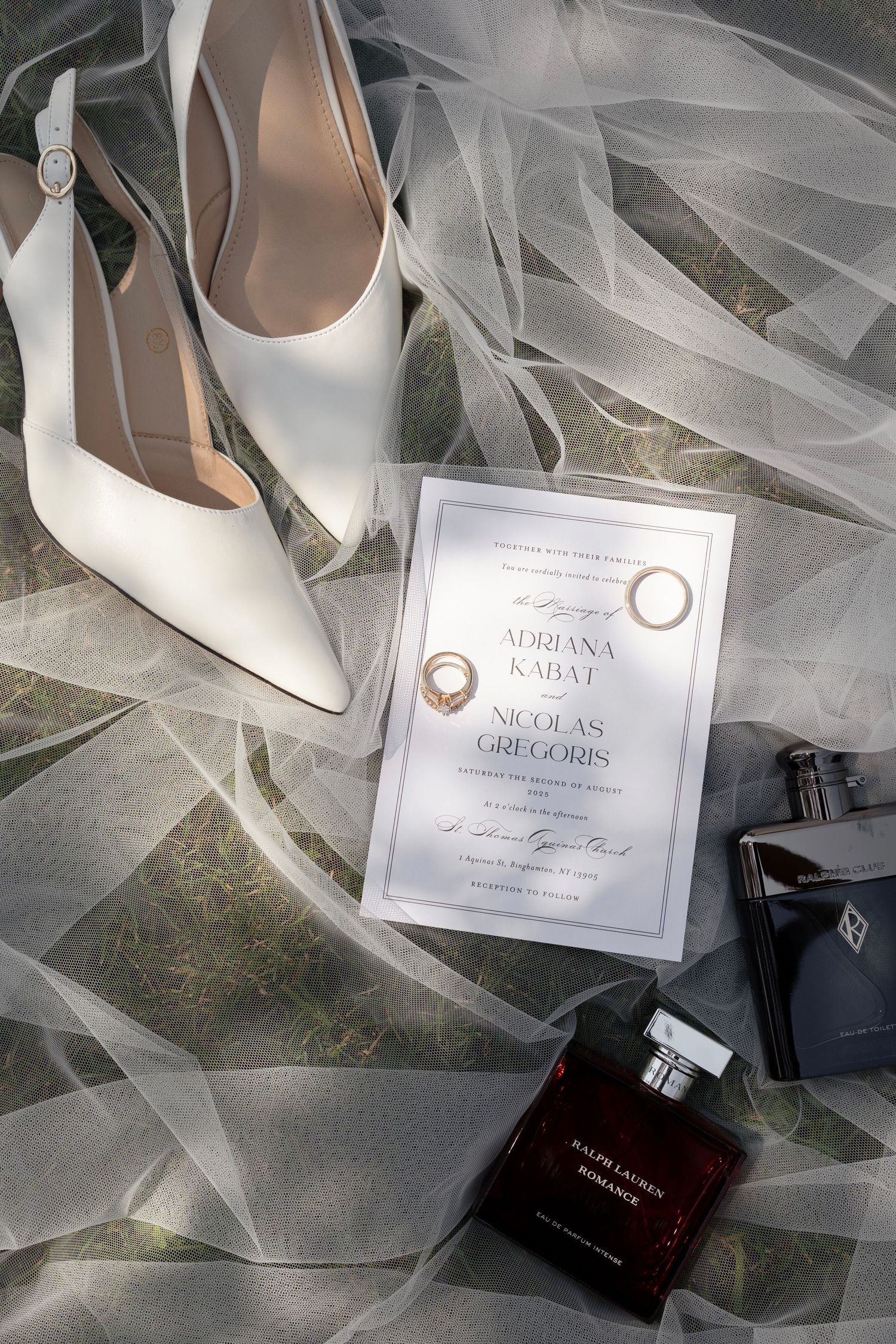 Wedding details including white shoes, veil, and invitation cards arranged artistically.