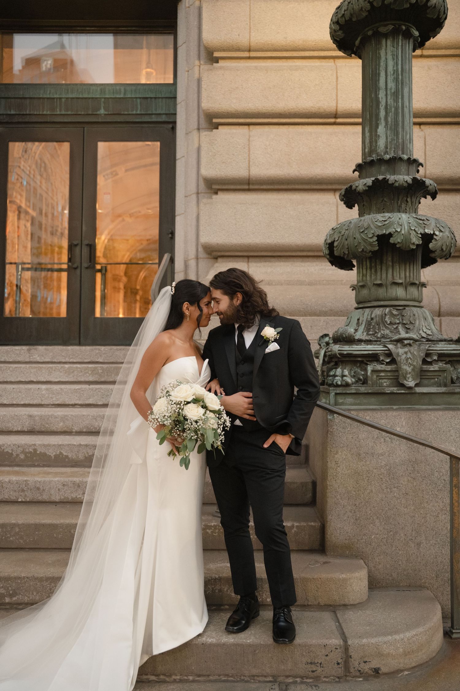 A romantic wedding couple shares intimate moments on stone steps of a historic building in a sequence of photos.