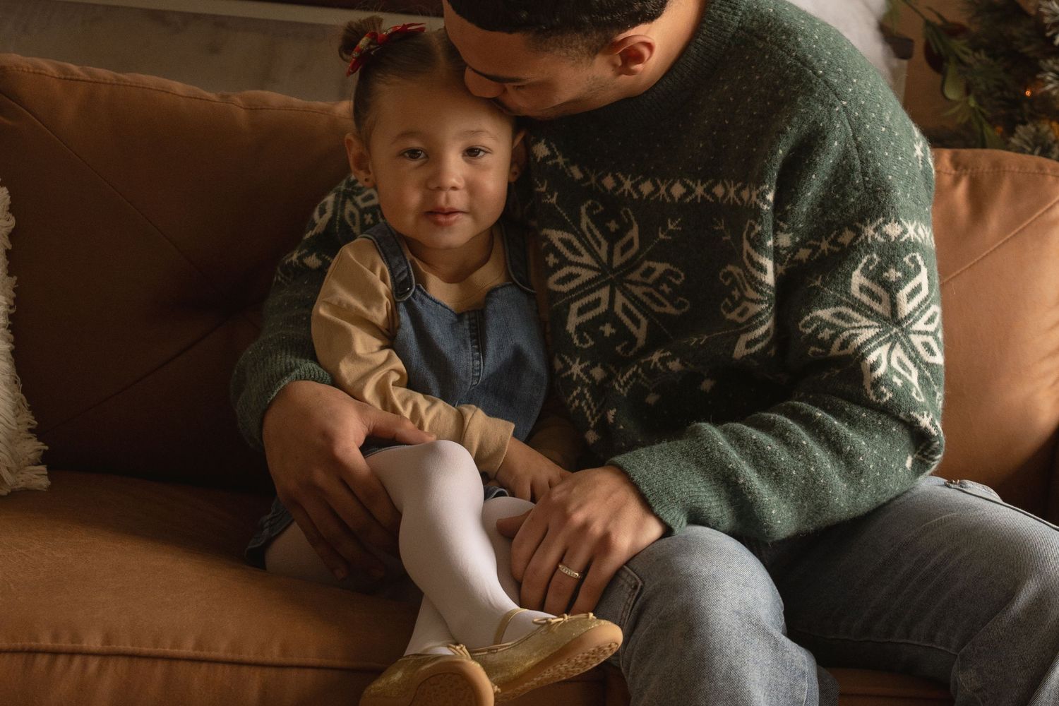 Intimate family gathering on couch during holiday season with festive studio decor.