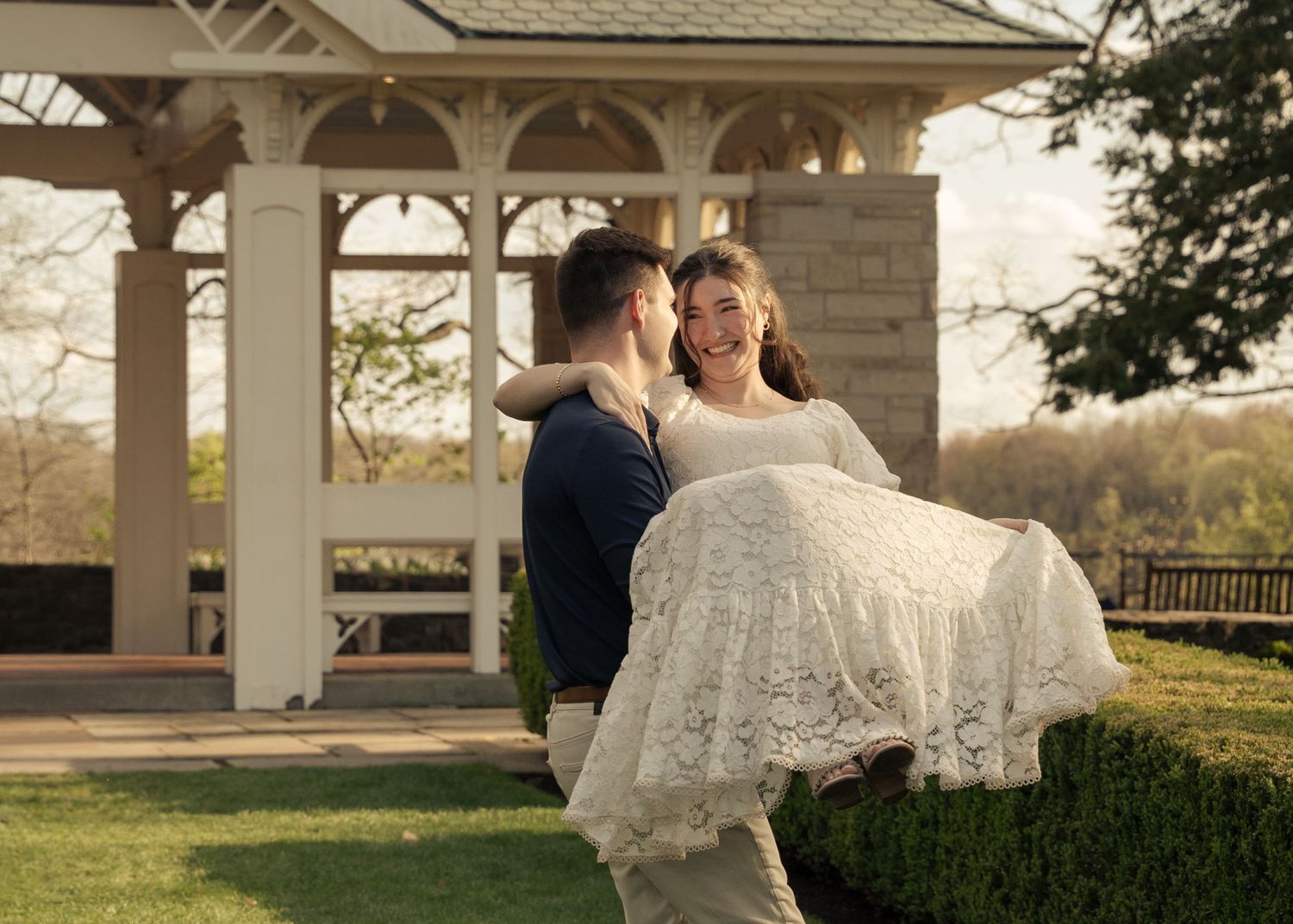 Couple dancing together under white gazebo during outdoor couples session.