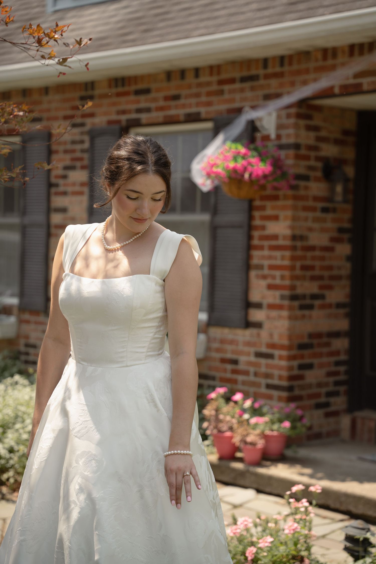 Elegant white wedding bridal portrait in natural sunlight against childhood home.