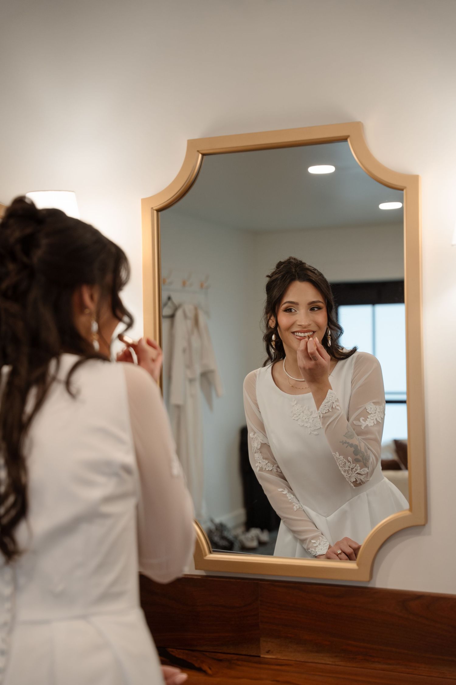 A series of joyful reflections in an ornate mirror during wedding morning preparations.