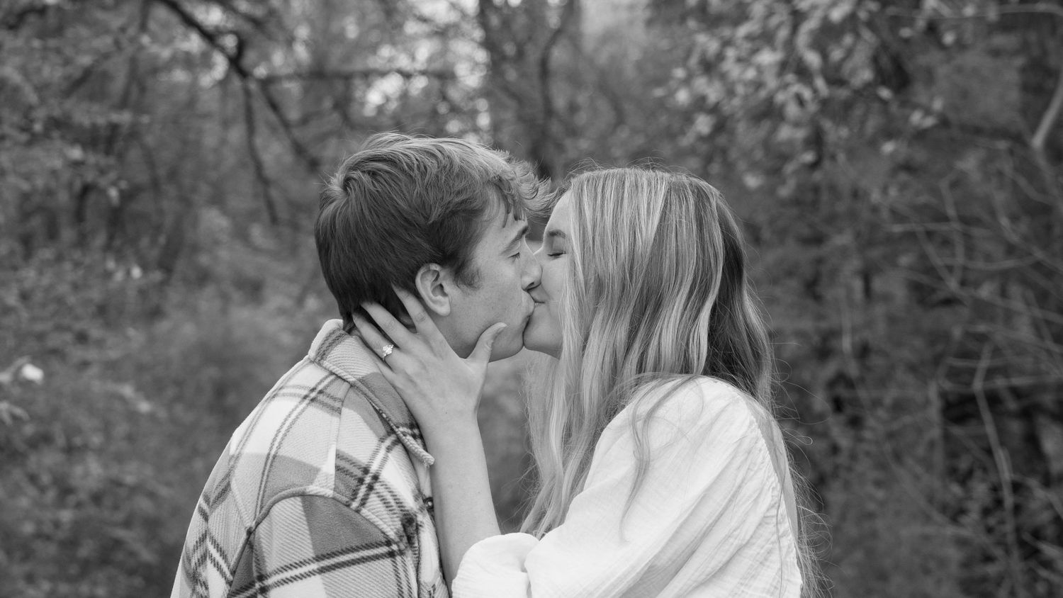 Romantic black and white portrait series of a couple sharing intimate moments outdoors.