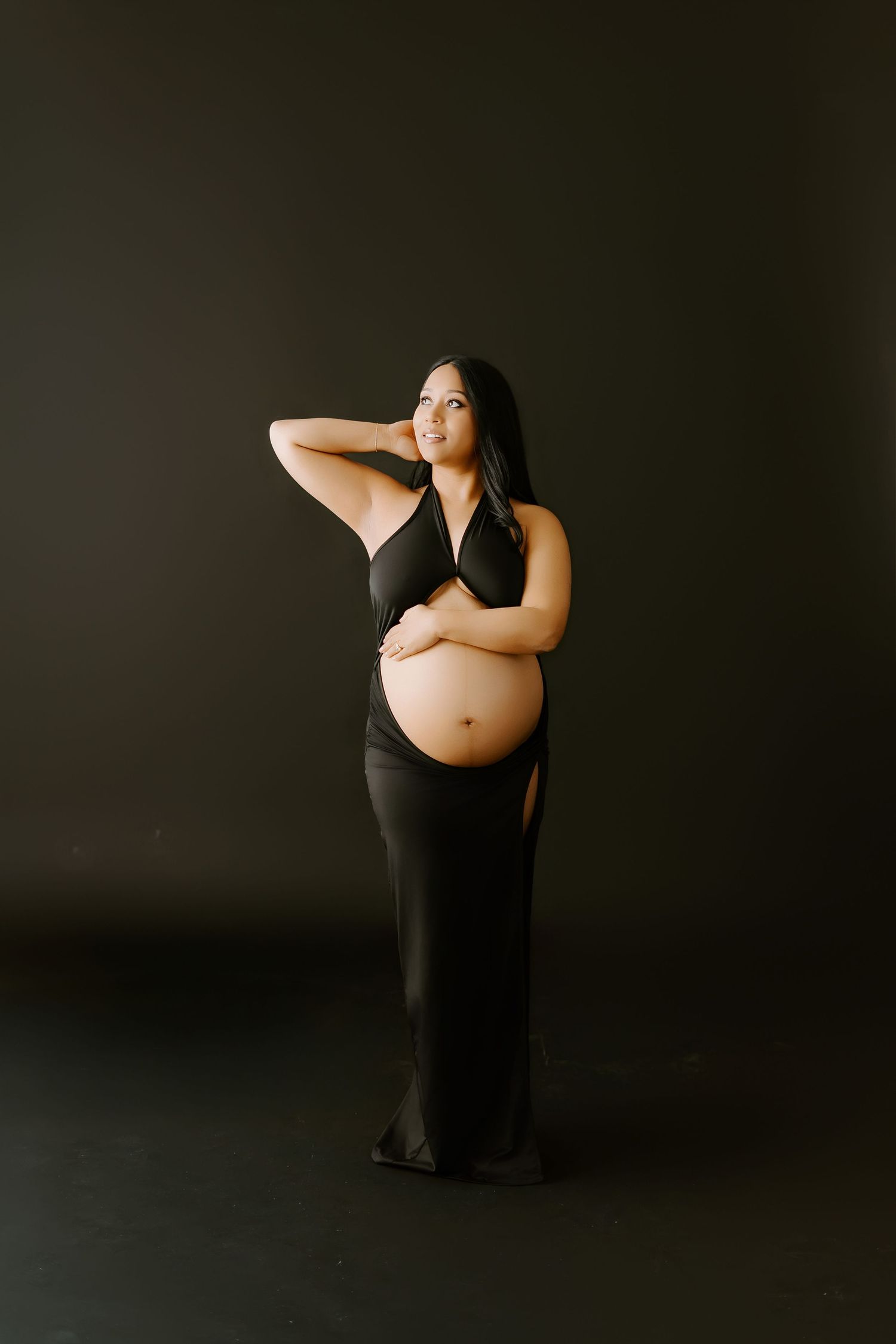 Artistic maternity photo series showing silhouette of pregnant figure against dark background in multiple poses.