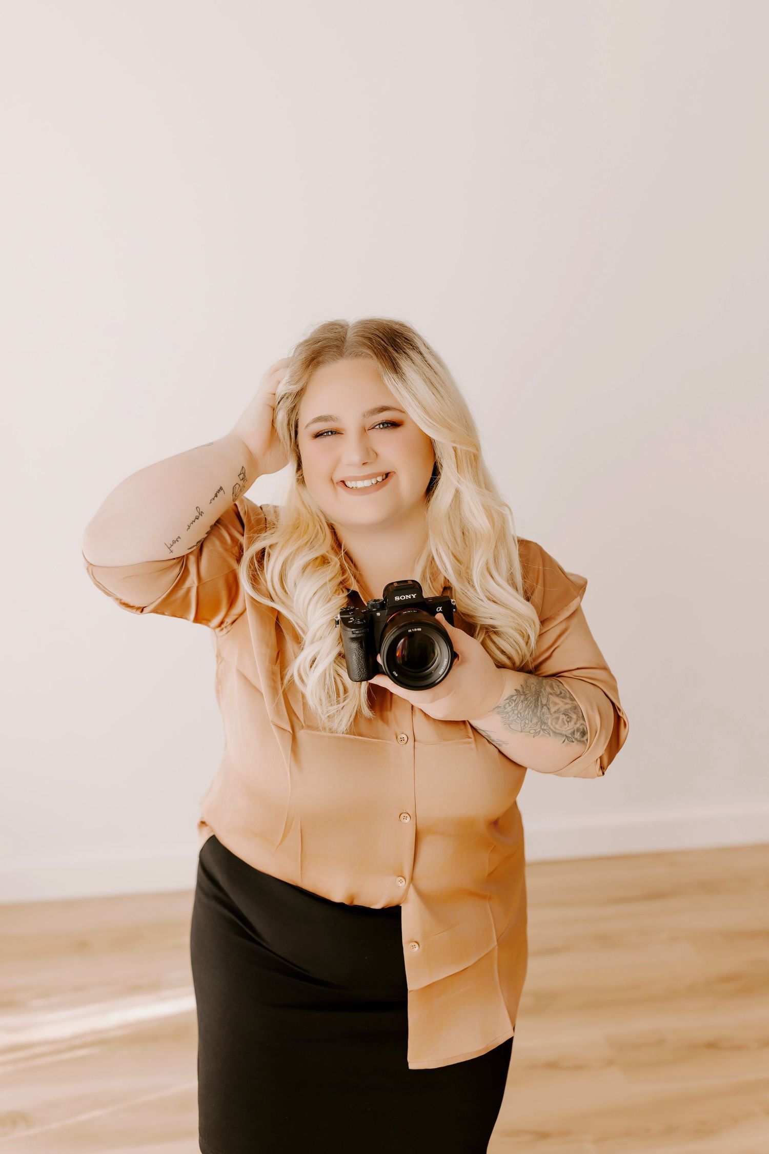 A person in a beige jacket and black pants poses playfully in a series of four candid studio shots against a white backdrop.