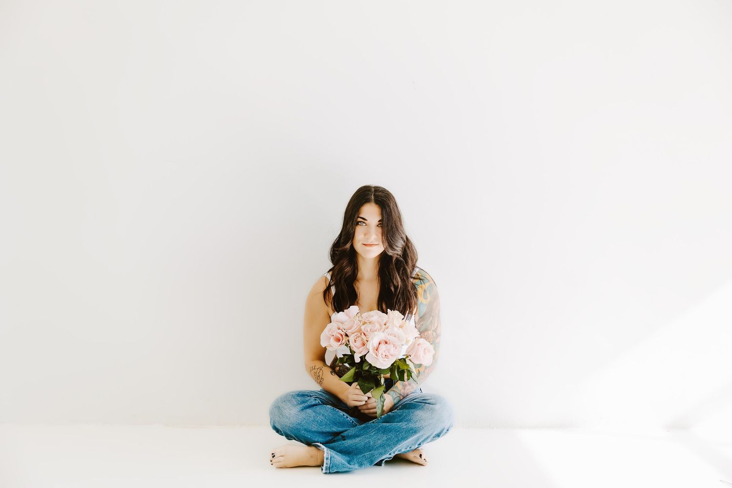Minimalist portrait series with woman and flowers against white background.