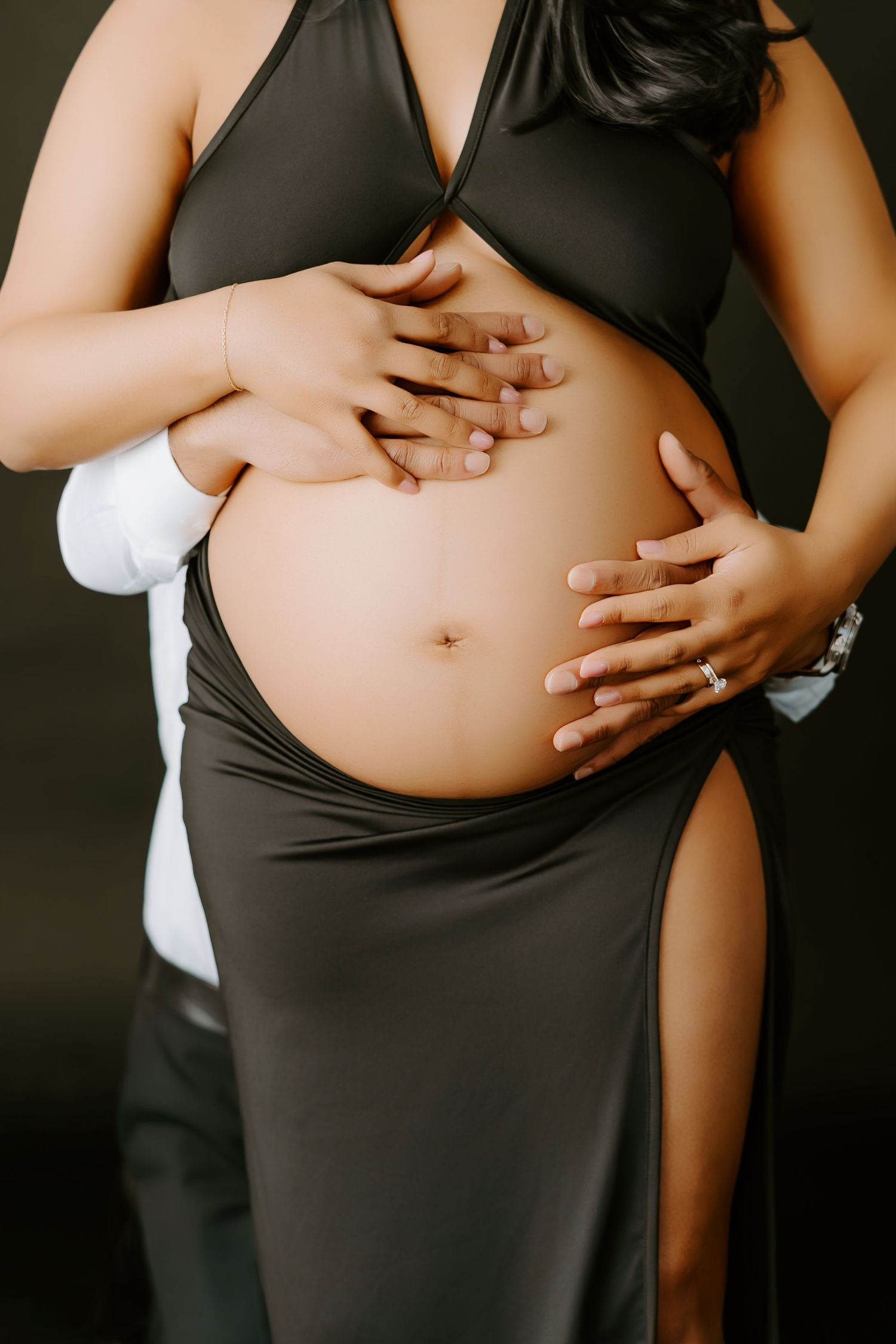 A series of maternity photos showing a growing baby bump against a black background in progressive stages of pregnancy.