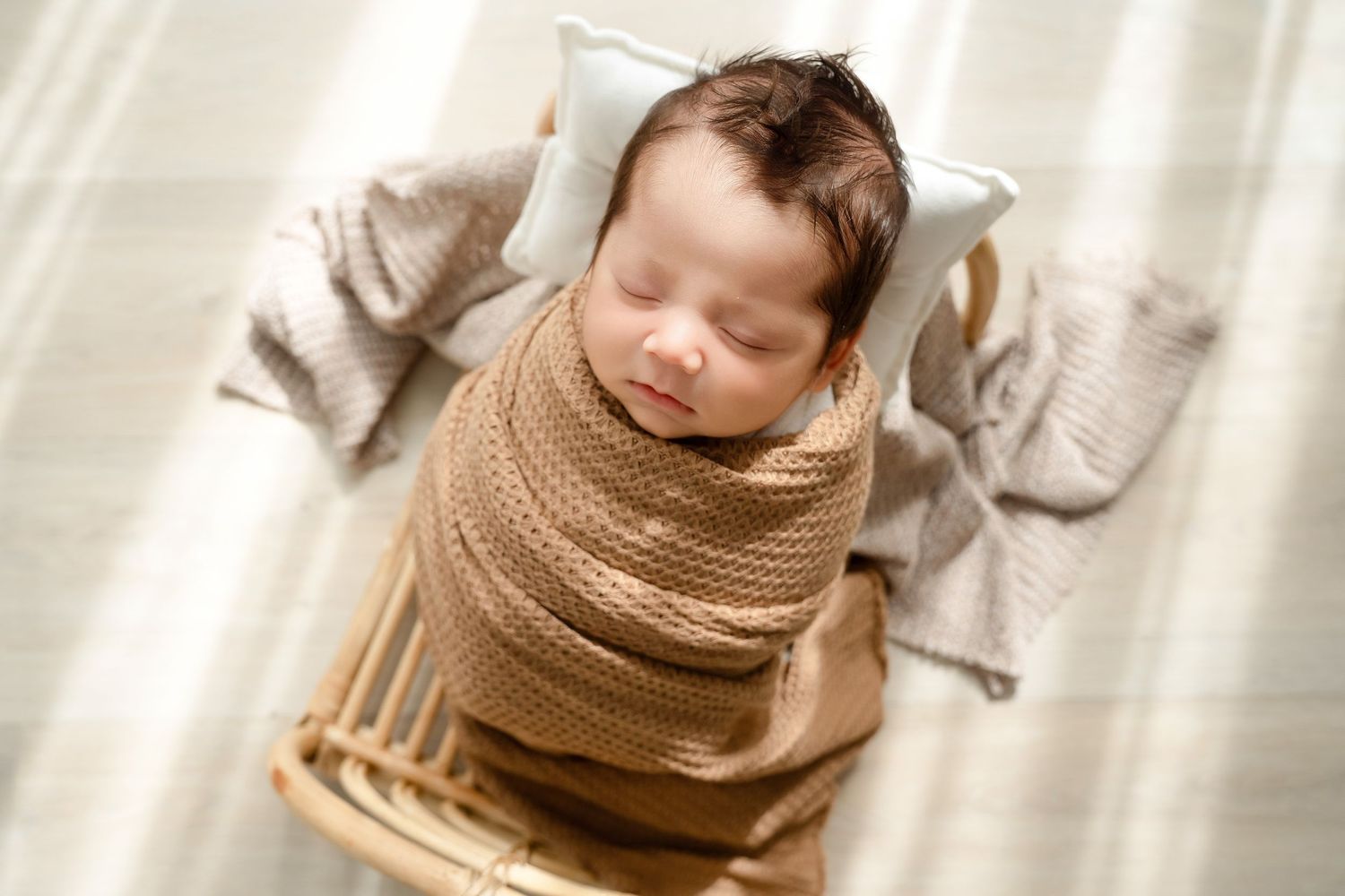Peaceful newborn photography series with baby wrapped in cozy brown knit blankets.