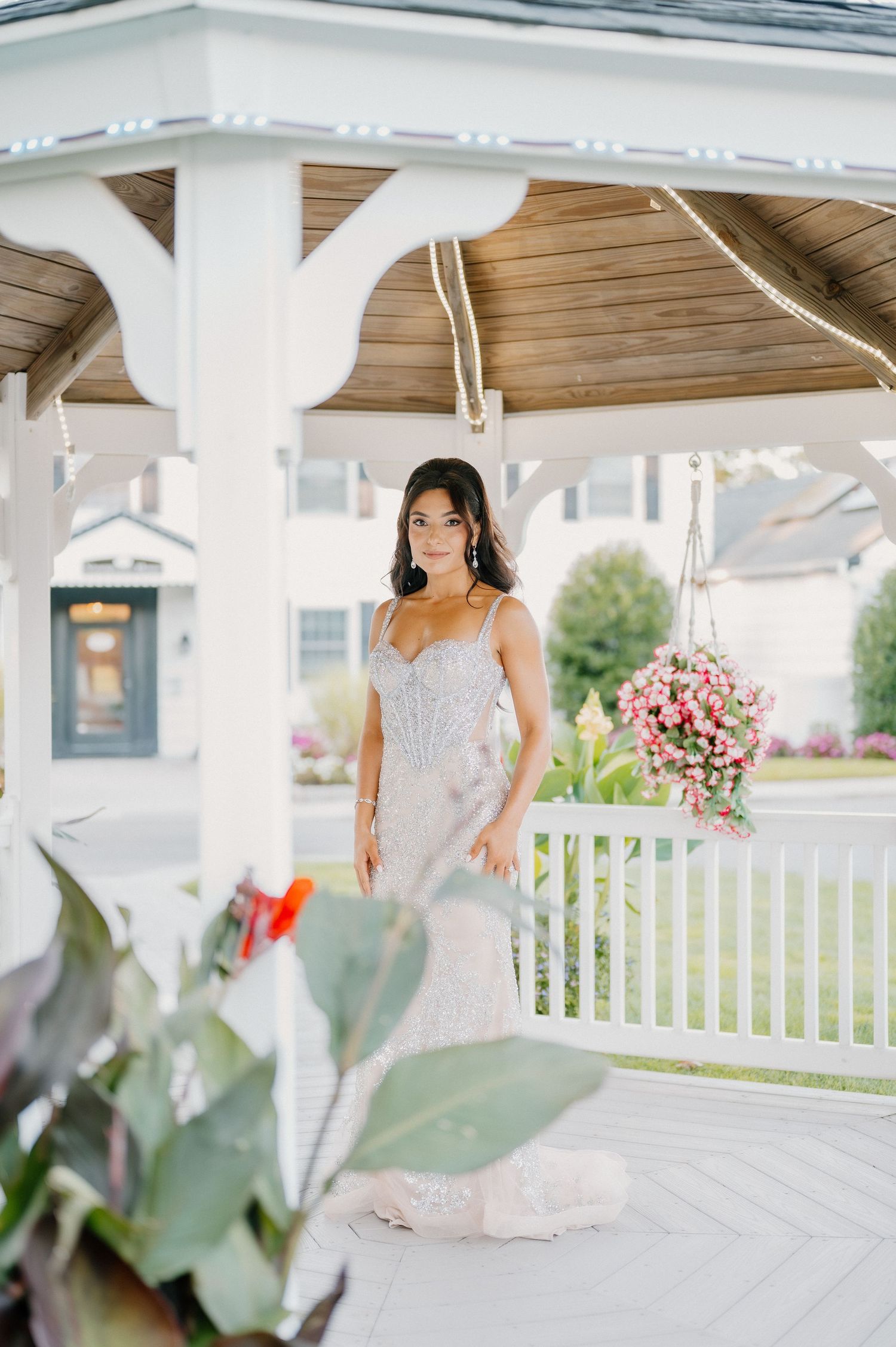 Elegant bridal portraits taken under white gazebo with floral arrangements.