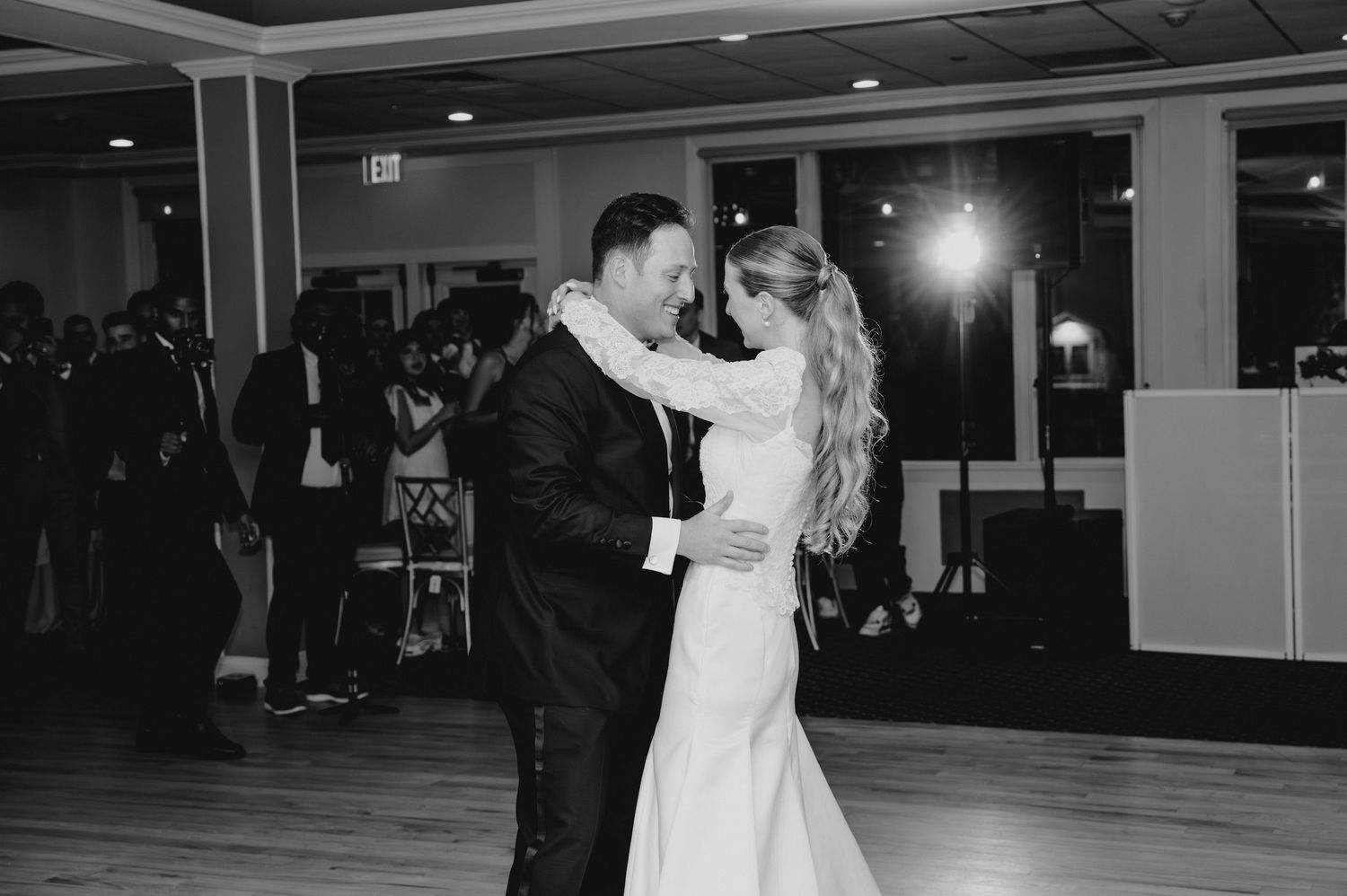Wedding reception dance floor moments captured in dark indoor venue.