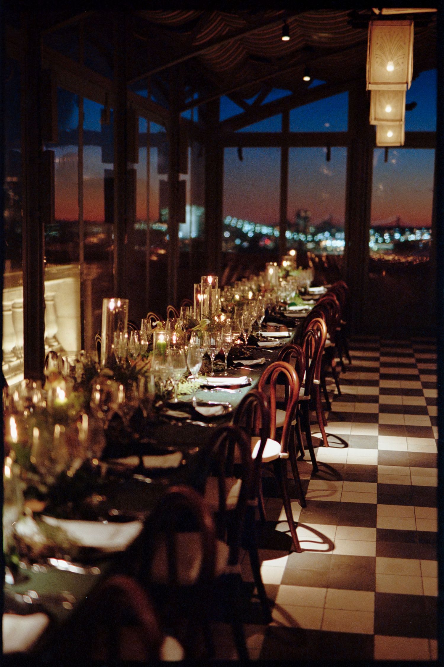 Elegant candlelit reception venue with checkered floor and romantic evening ambiance.