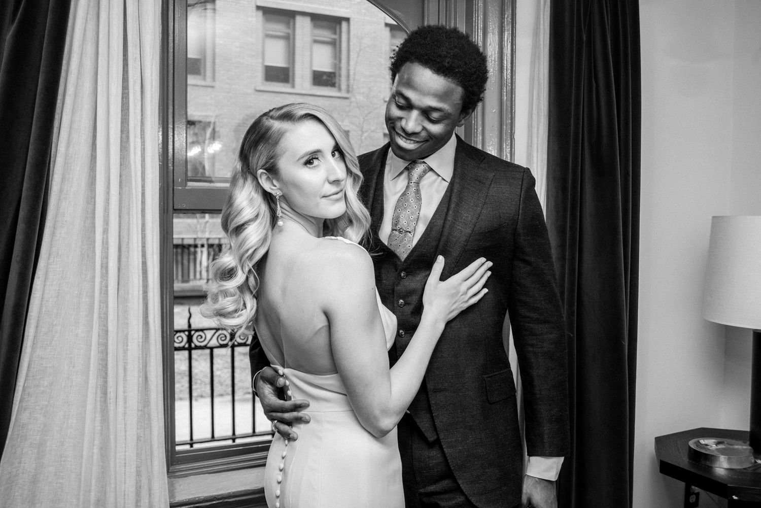 Intimate wedding portraits taken against a window with natural lighting.