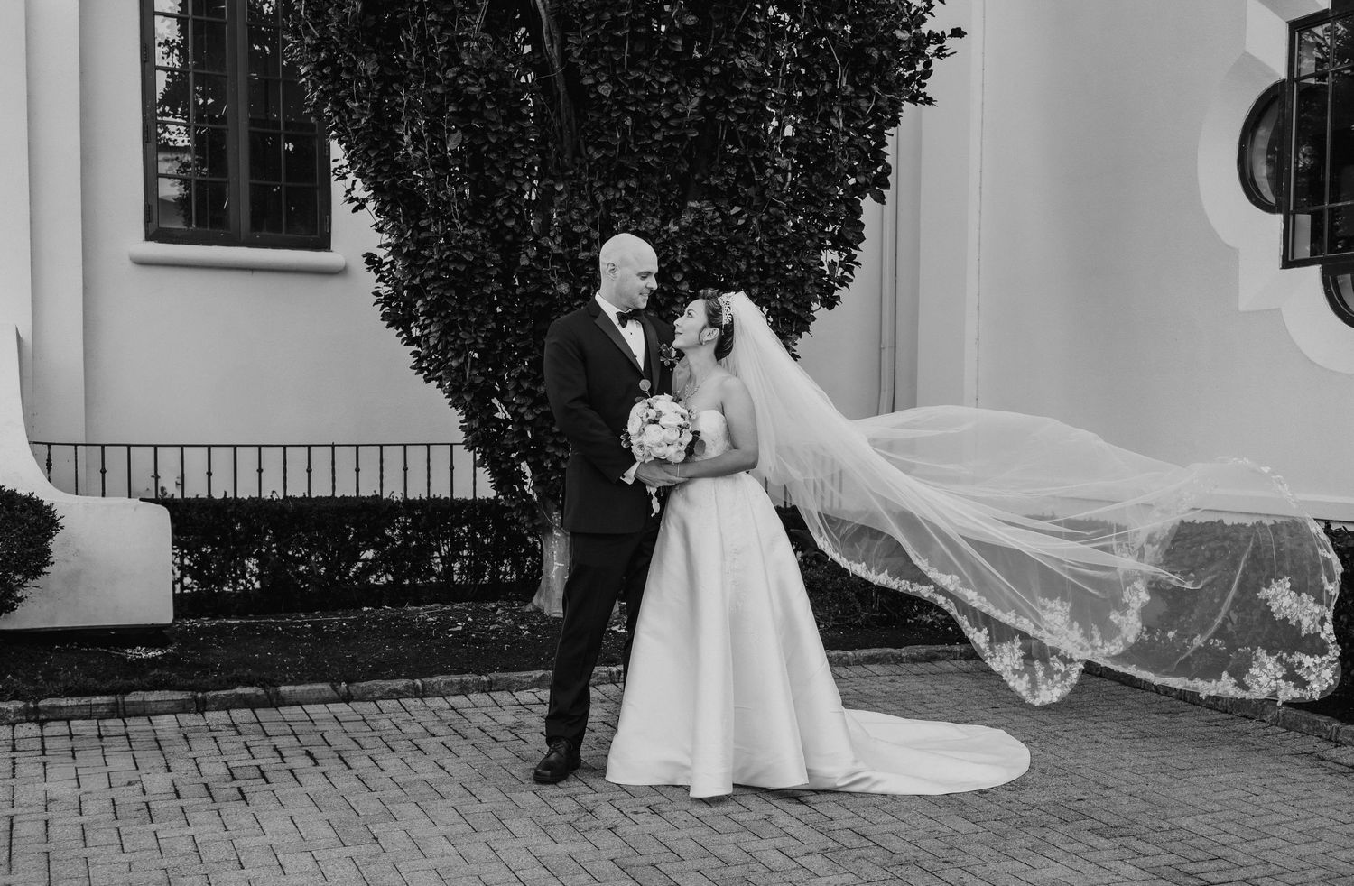 Black and white panoramic series of wedding moments captured at an elegant outdoor venue.