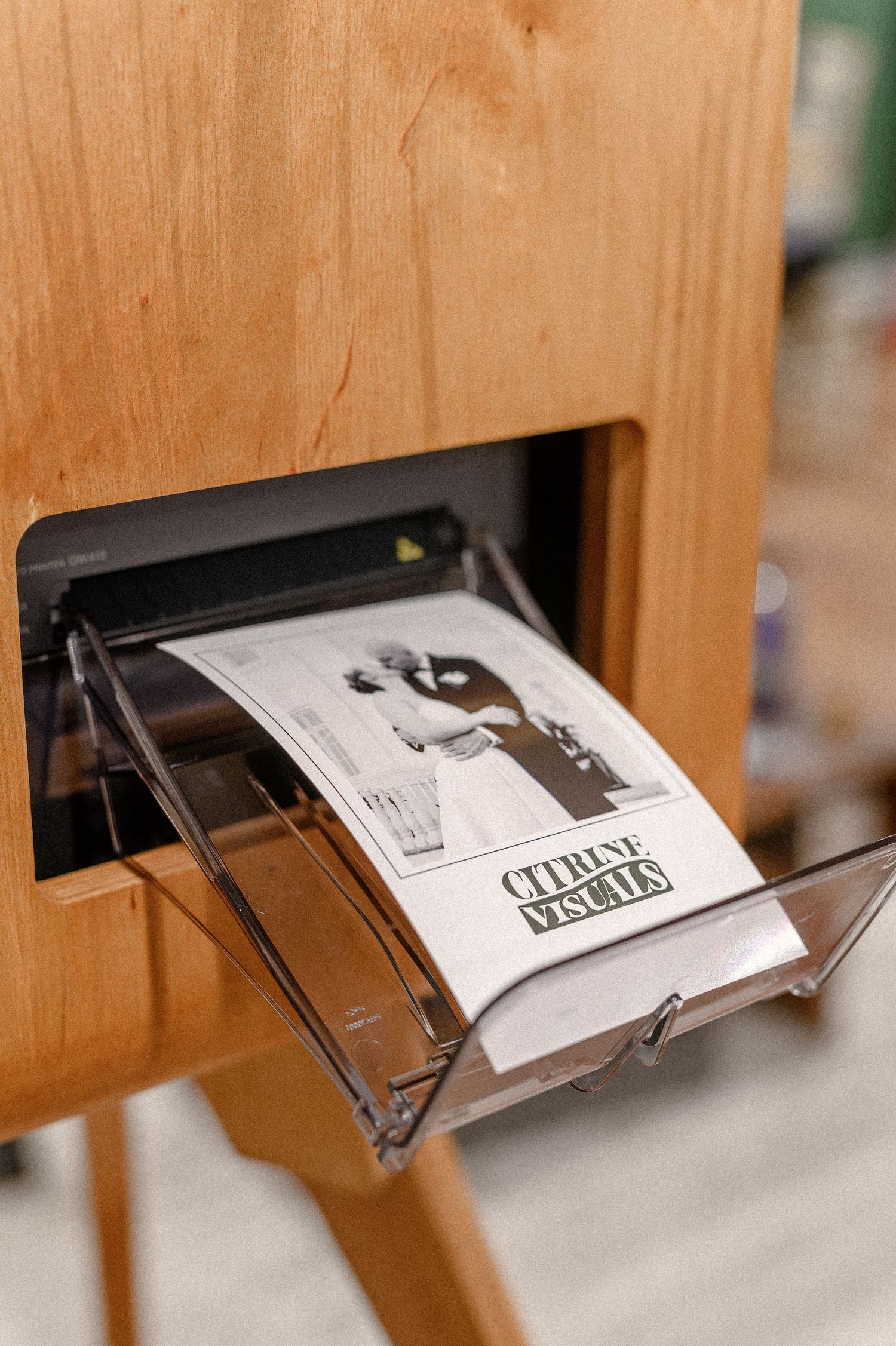 Four sequential images showing a magazine or brochure being pushed through a wooden mail slot.
