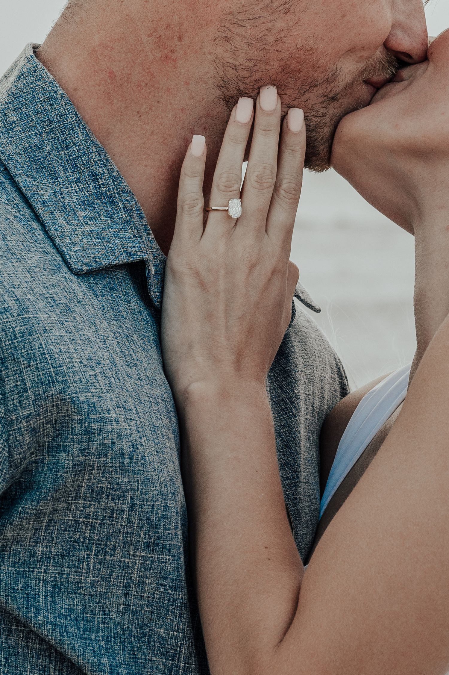 Close-up of an engagement ring displayed during an intimate moment.