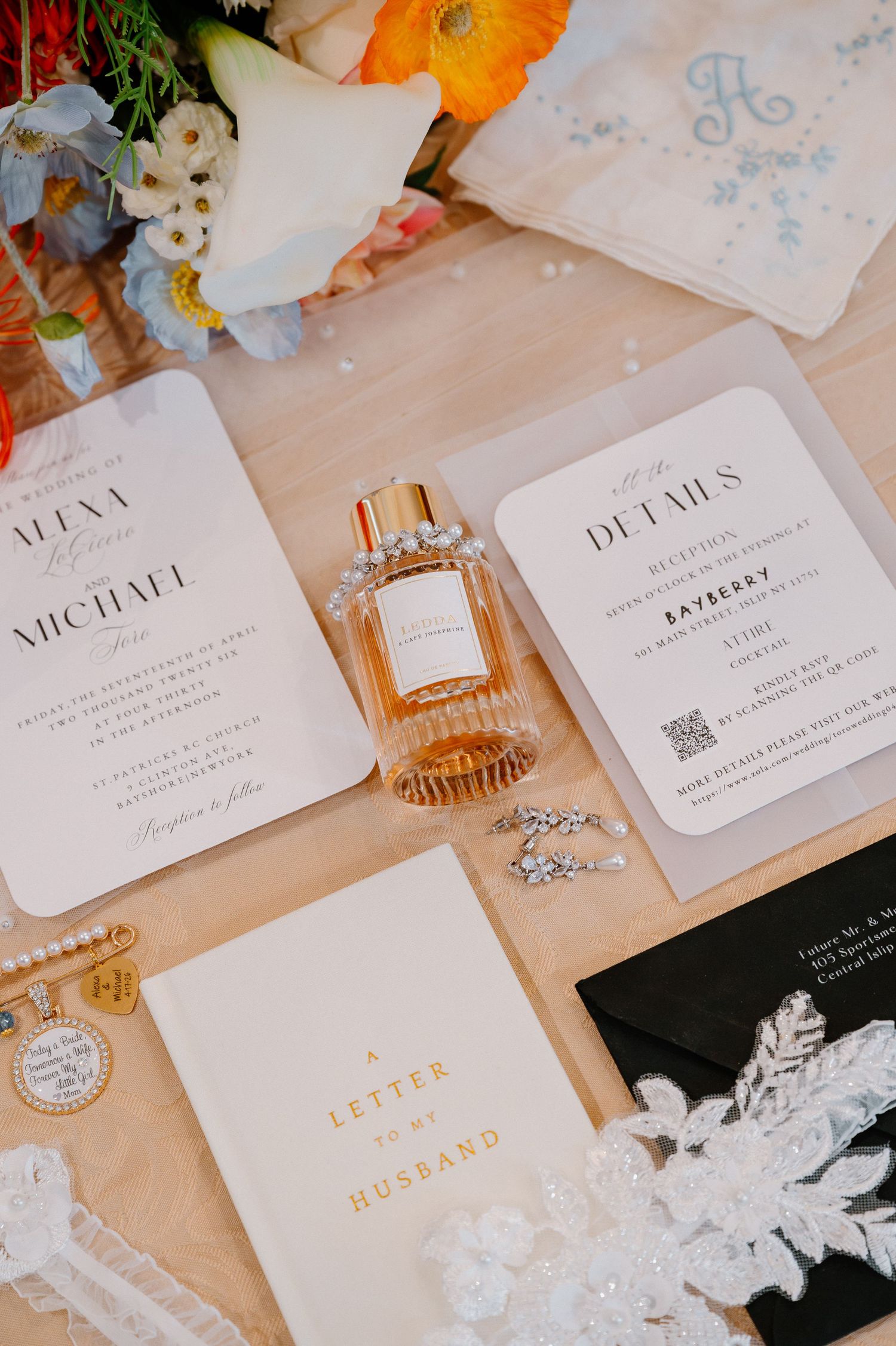 Elegant wedding flat lay with invitation suite, perfume bottle, rings, and a letter to my husband card on a neutral background.