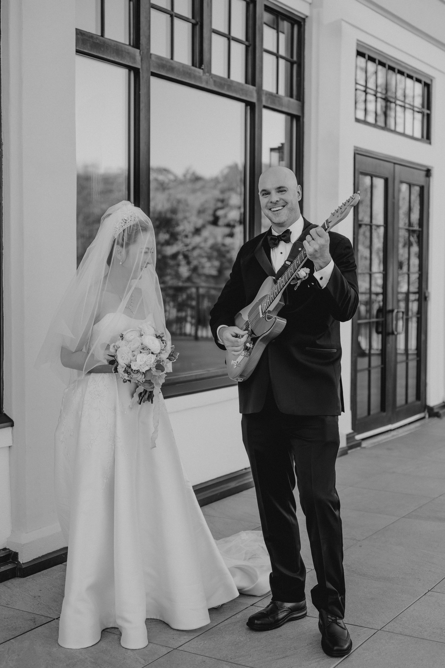 Black and white wedding photos showing sweet moments between the couple outside a modern building.