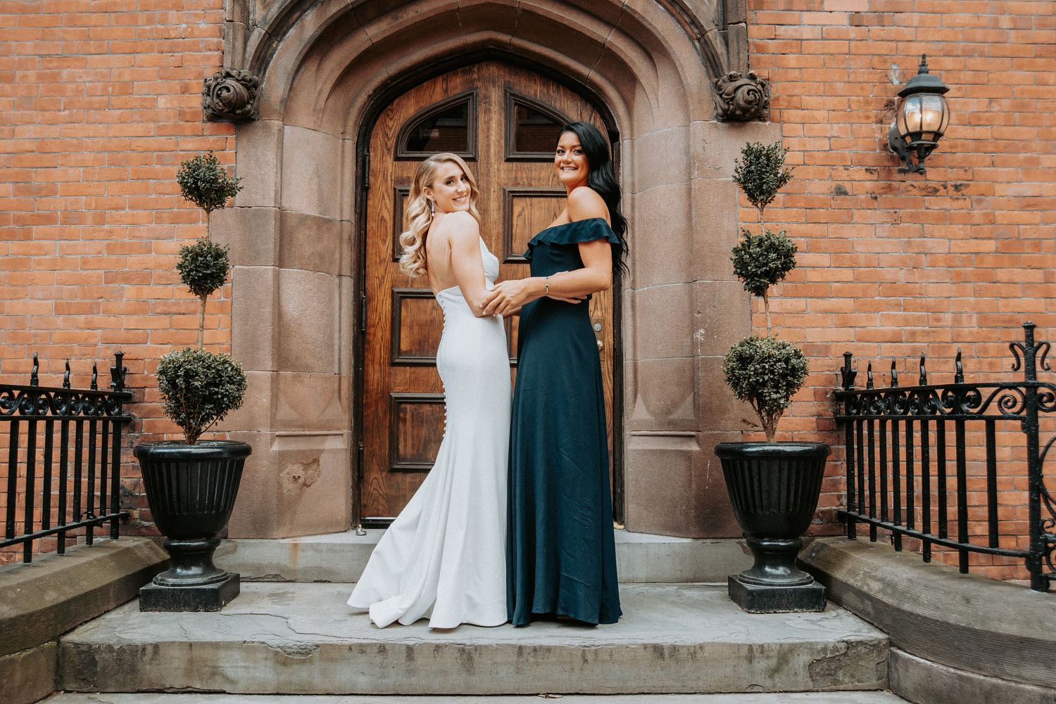 Wedding photos taken outside a brick church with ornate architectural details.