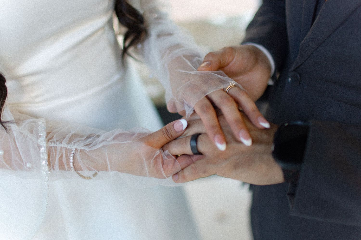 Close-up shots of hands exchanging rings during a wedding ceremony.