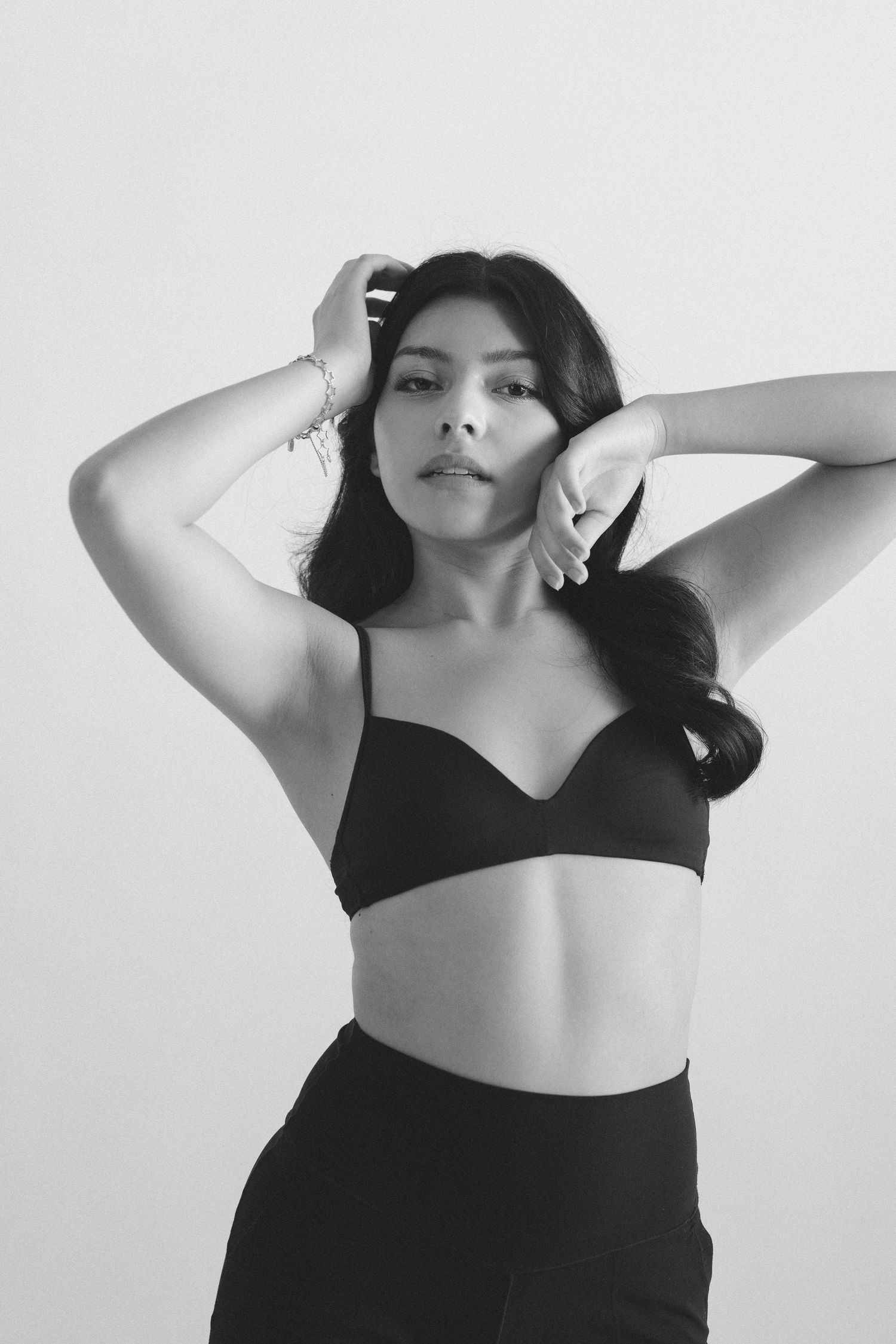 Black and white artistic portrait series showing graceful poses against a light background.