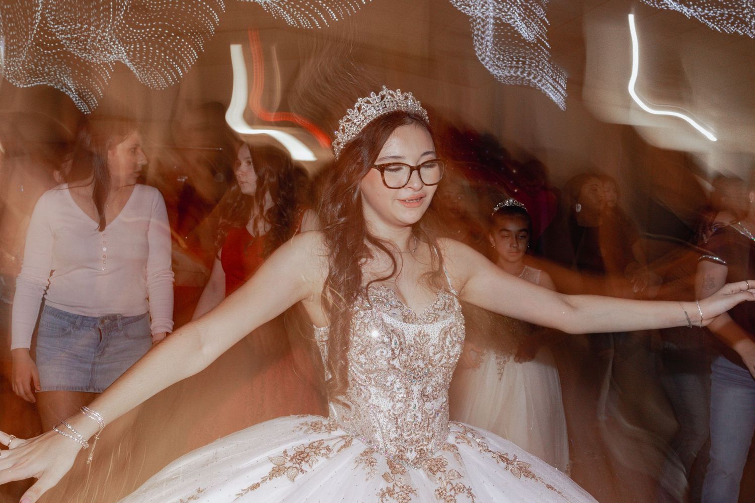 Dancers move across a festively lit ballroom floor during a celebration event.