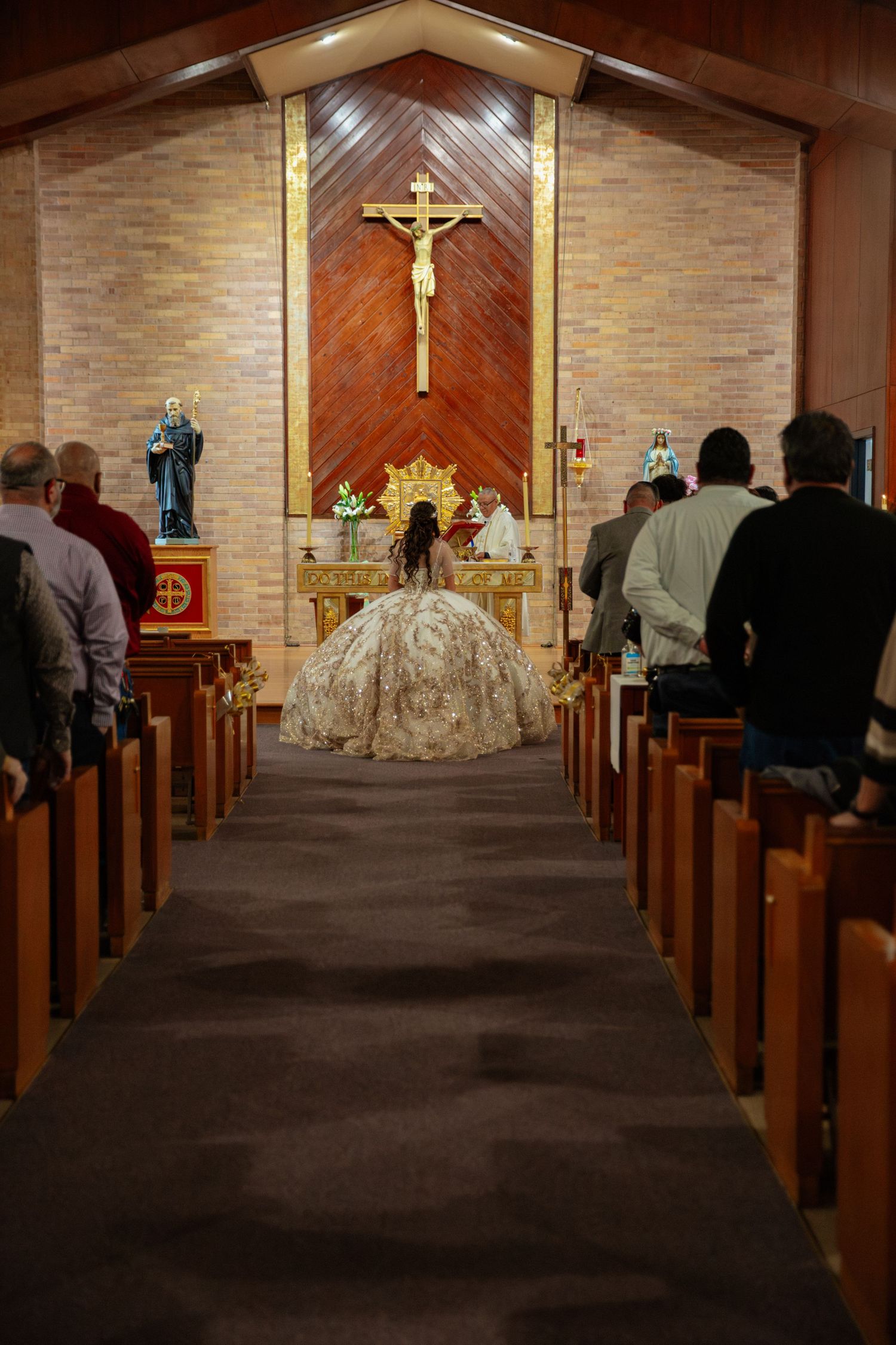 Interior of a church sanctuary with wooden pews and stone walls during a ceremony.