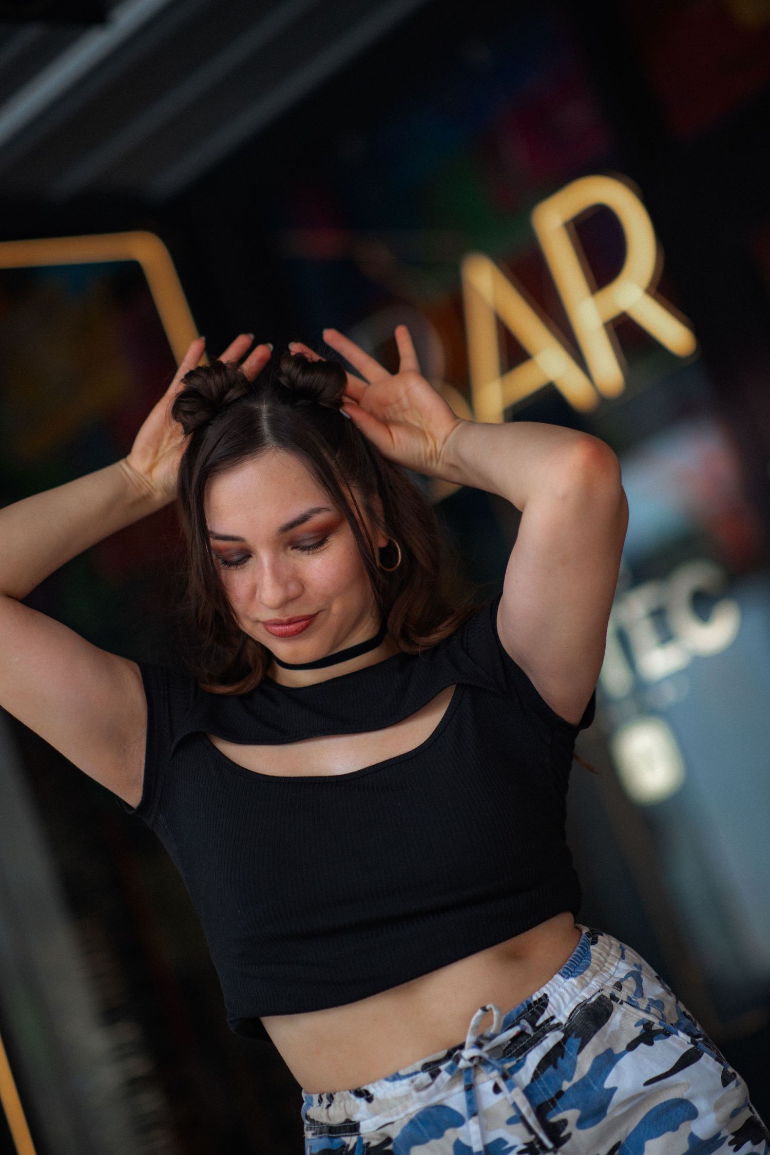 Energetic dance-inspired poses in urban setting wearing black crop top and camo pants.