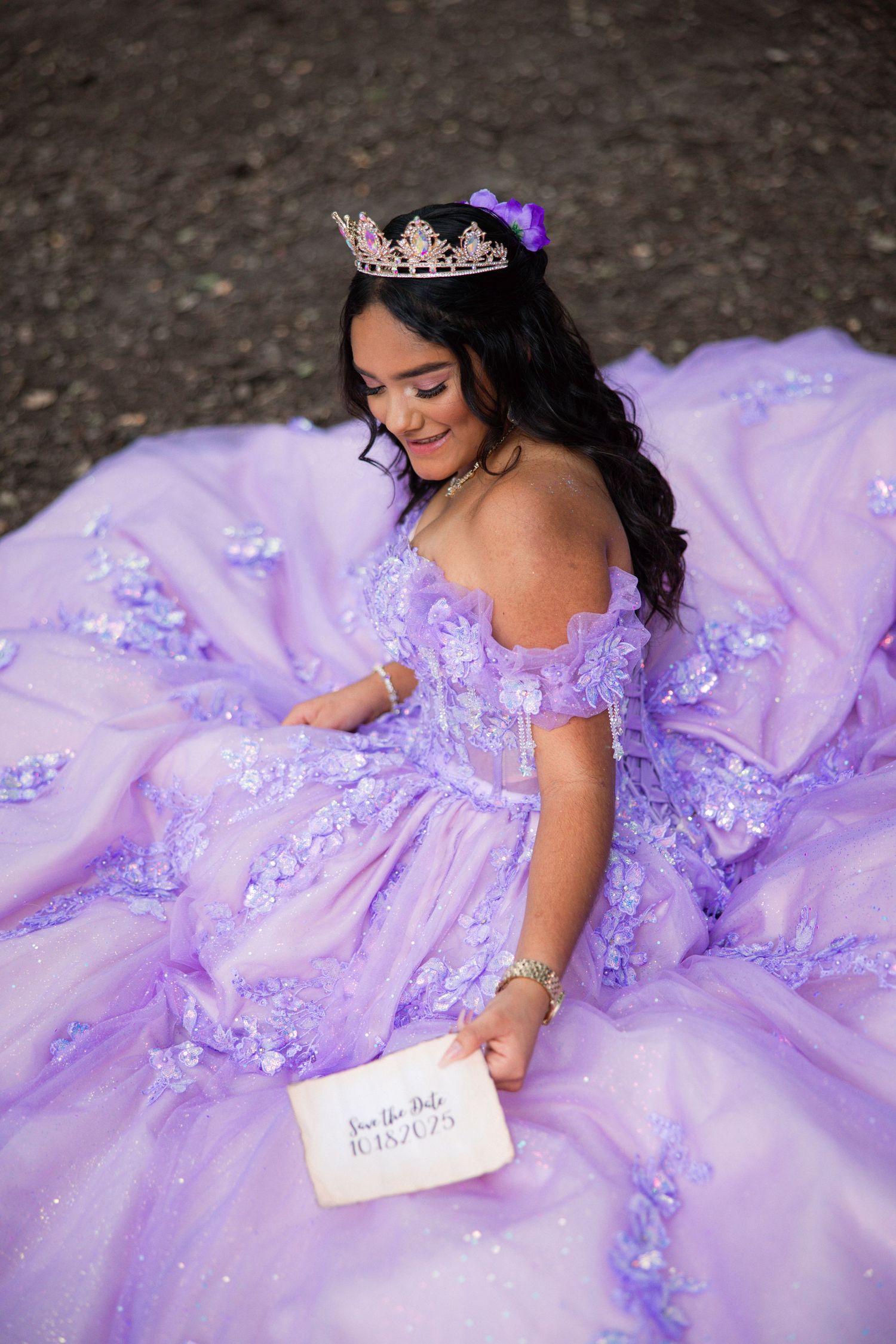 Lavender ball gown with sparkly details spread out on dark ground with handwritten note.