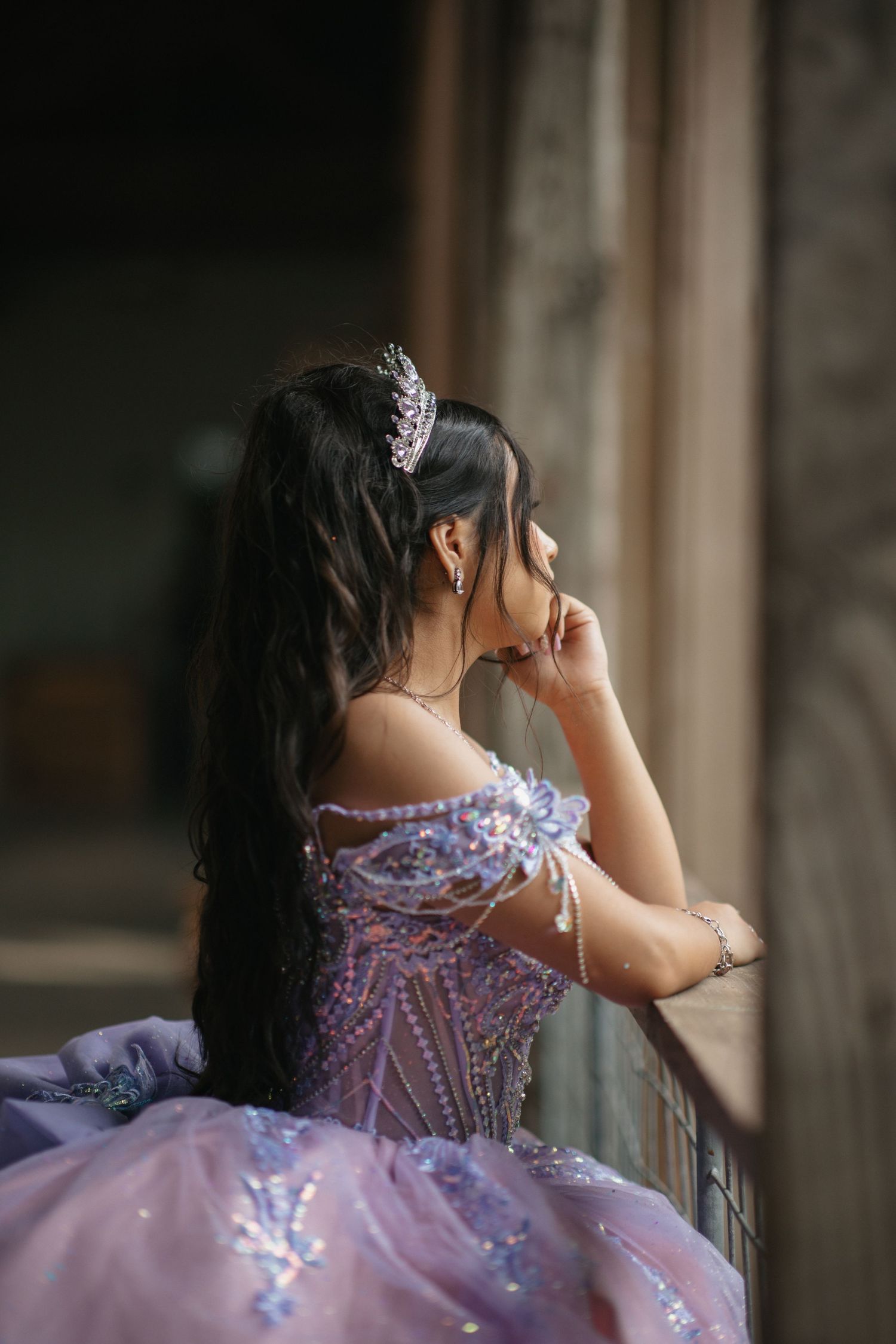 A detailed back view of a pink and purple gown with intricate beading and corset design.