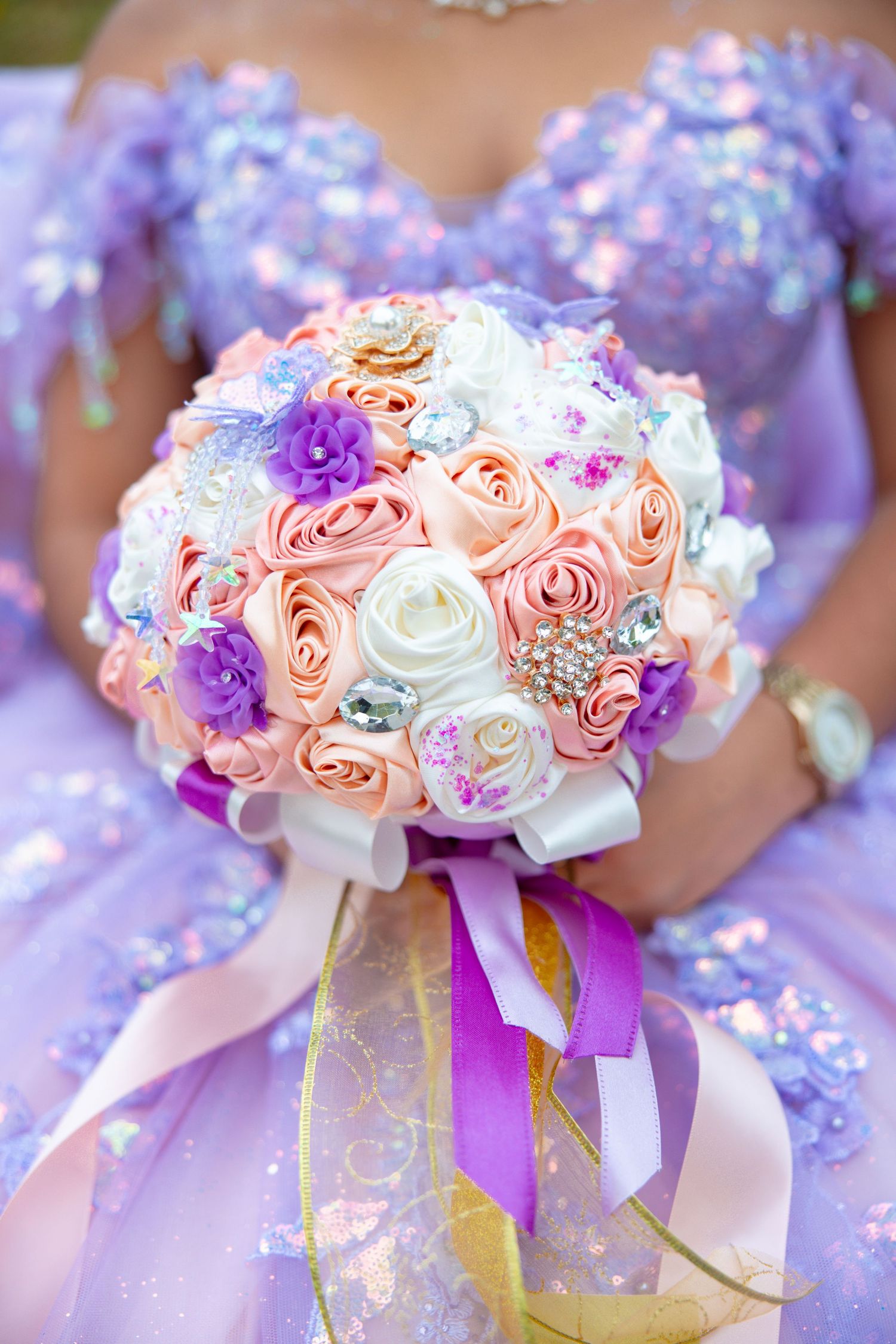 Delicate bouquet of pink and purple roses with ribbons matching a lavender quinceañera theme.
