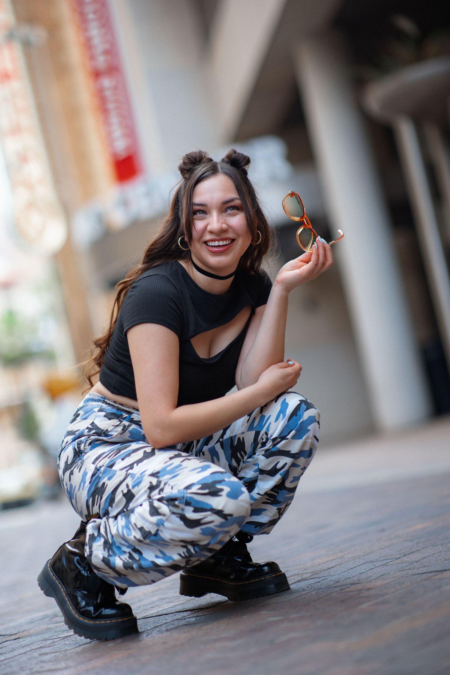 Dynamic fashion poses on wooden surface wearing camo pants and black top.