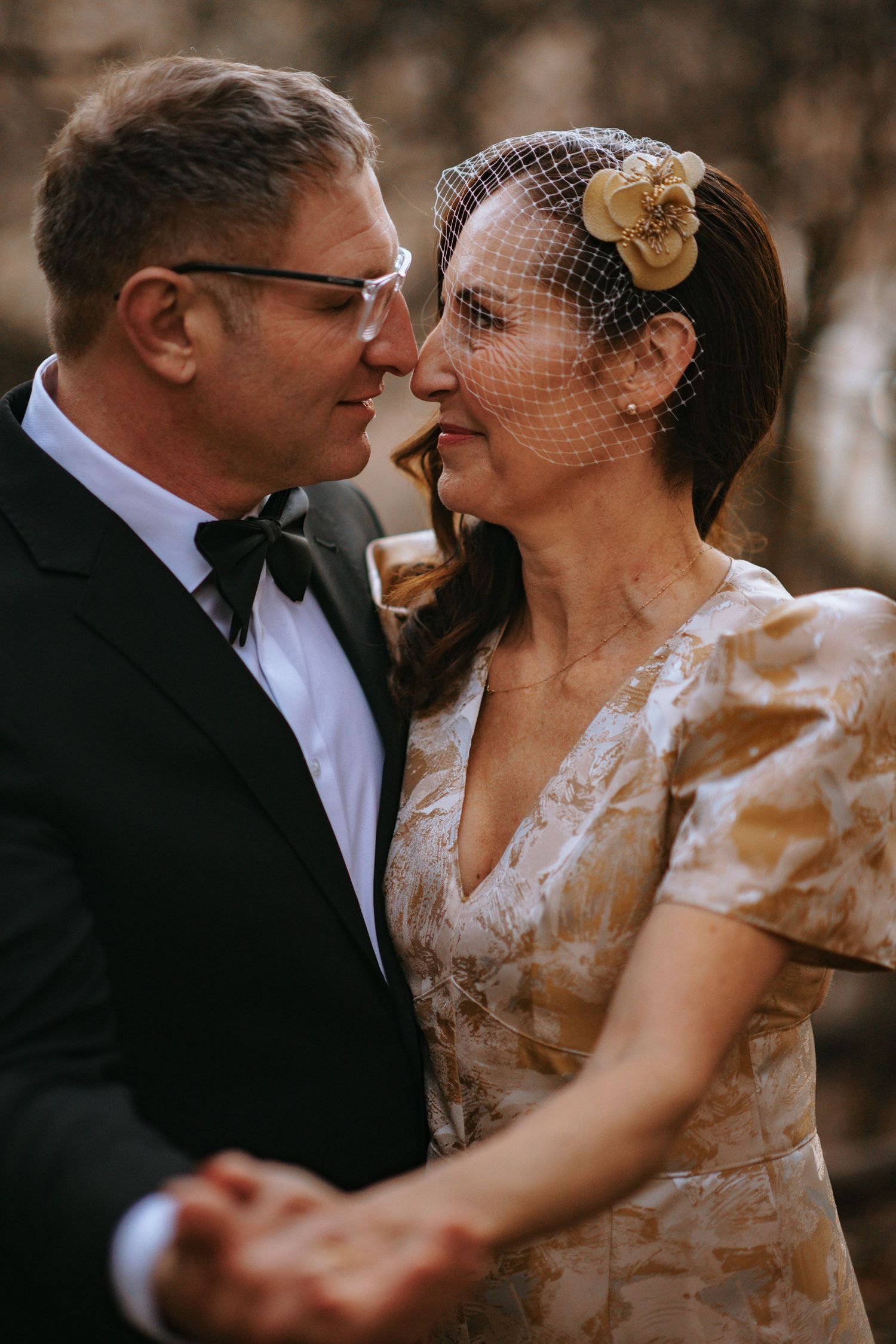 Couple in vintage-style wedding attire share intimate moment during ceremony.