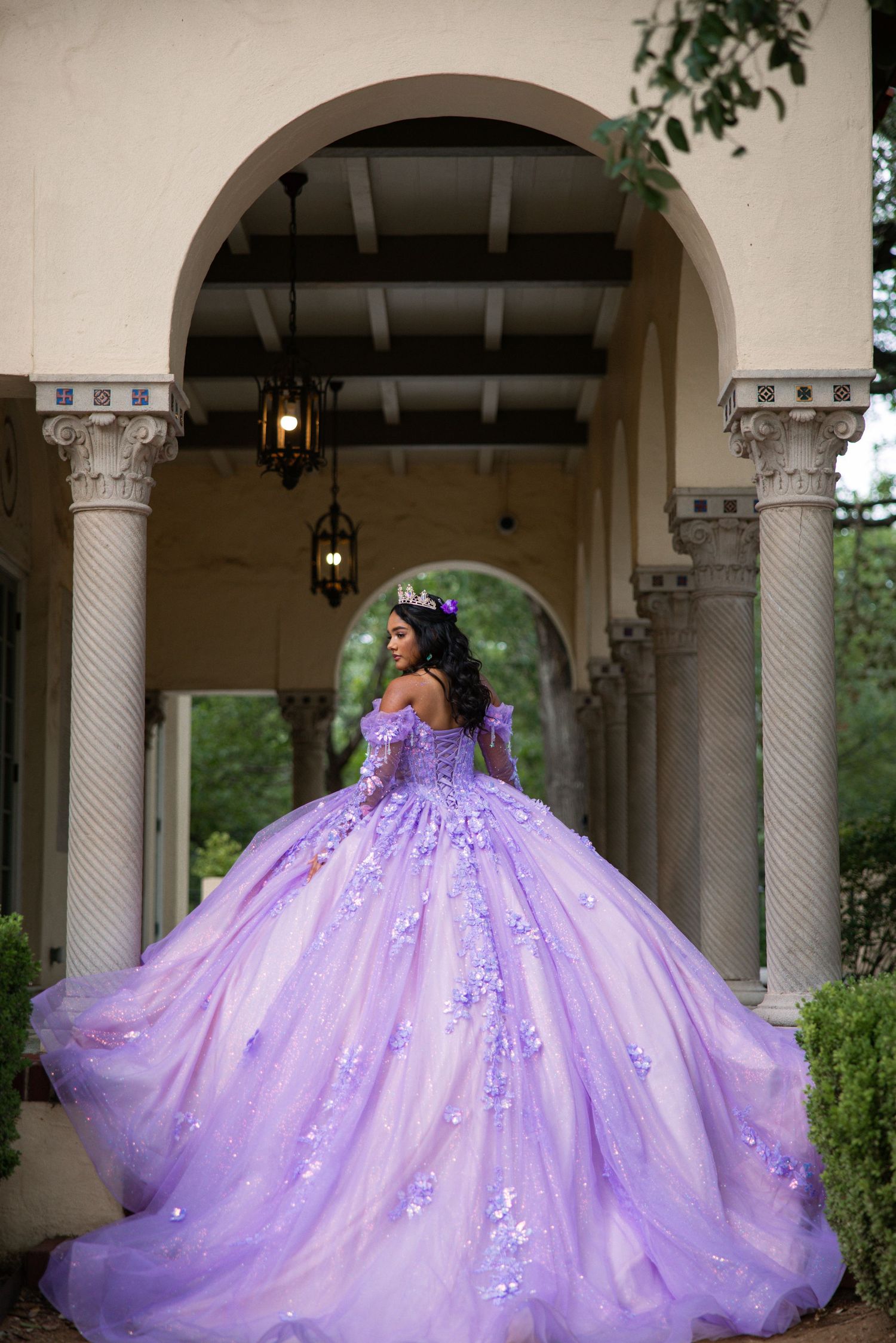 Lavender princess ball gown with sparkling details photographed under classical archways.